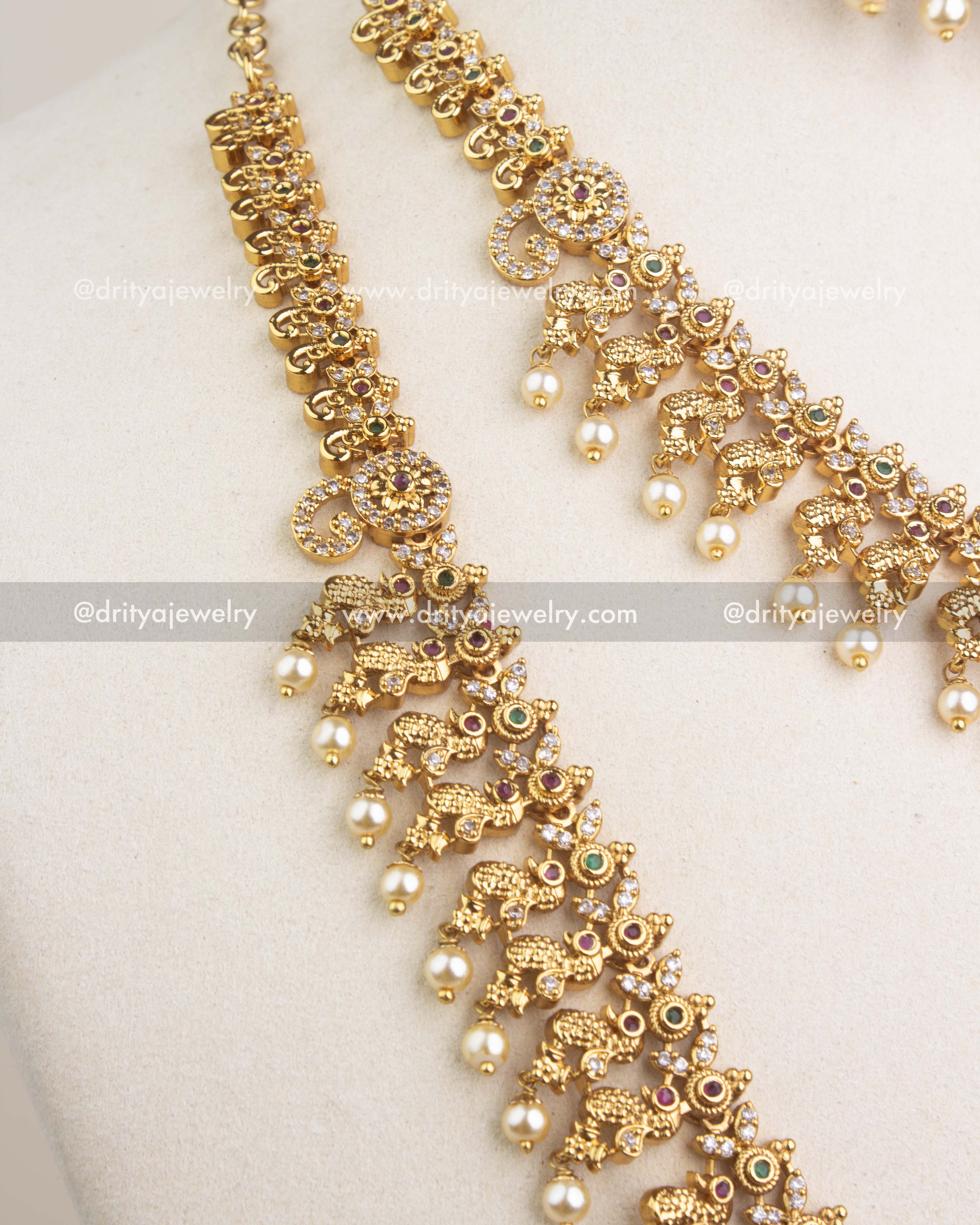 Close-up of short temple necklace with peacock motifs, stones and pearl hangings.