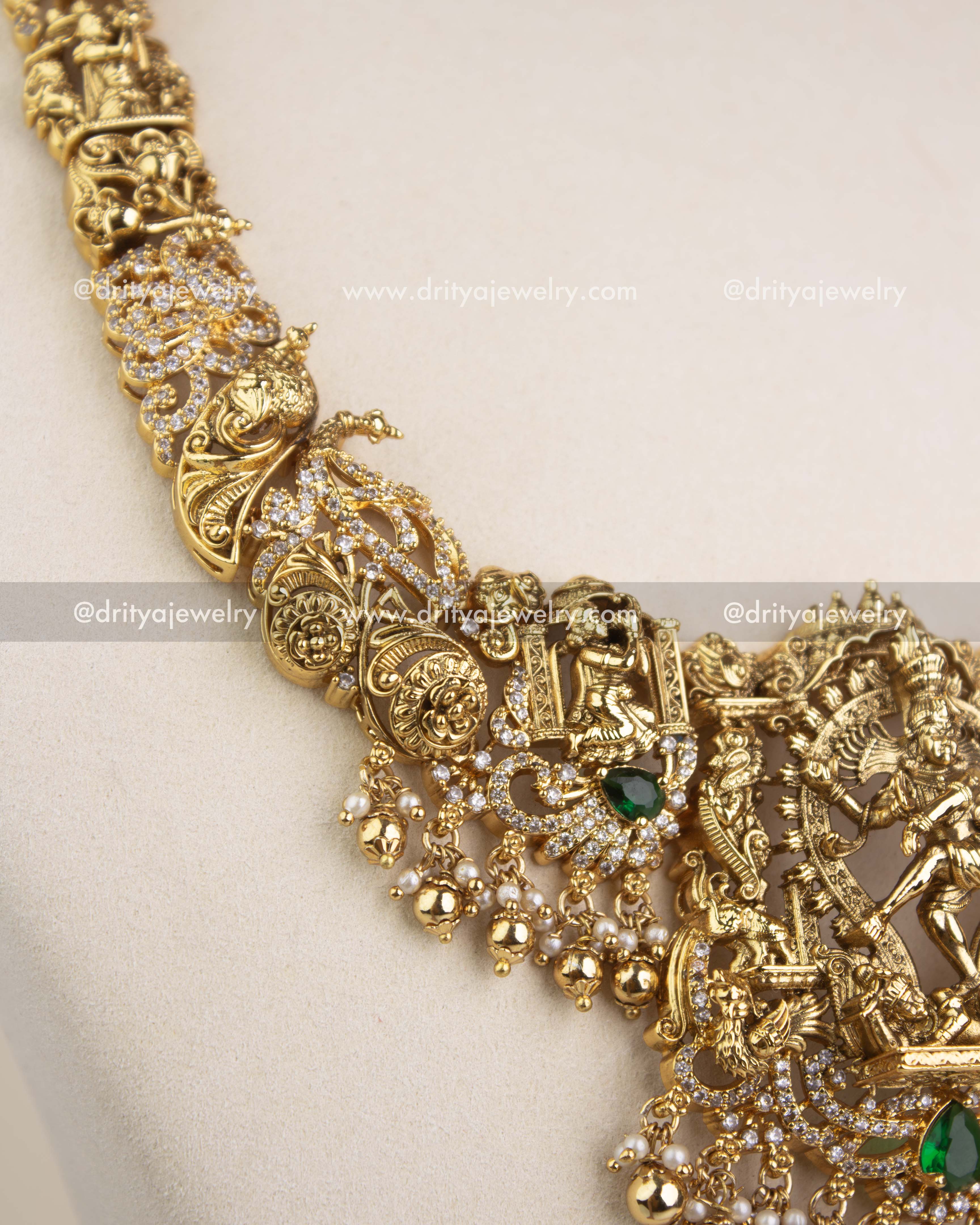 Intricate Nakshi chain design with miniature figurines, carvings, and green stone accents.