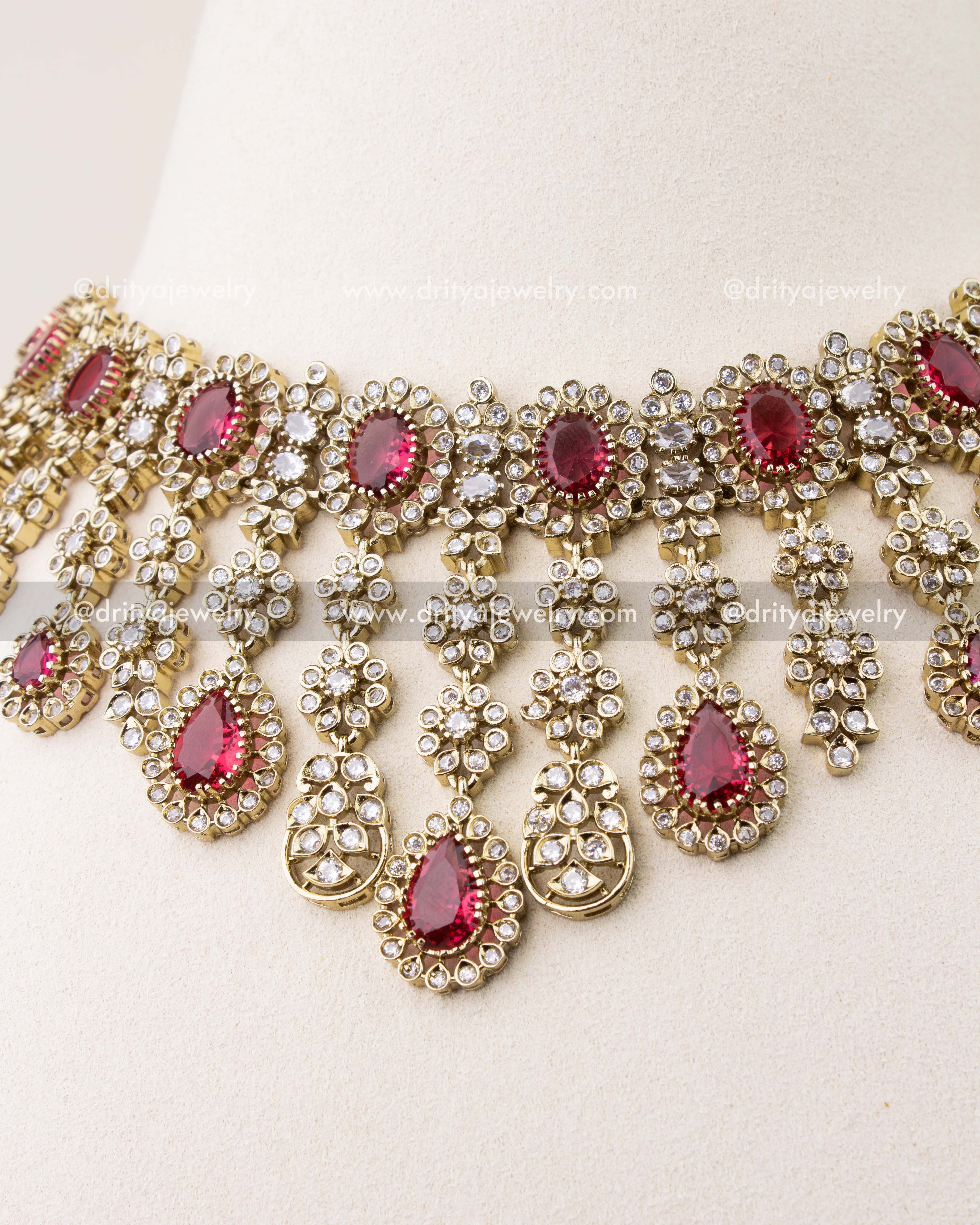 Close-up of ruby red stones with Victorian gold polish necklace