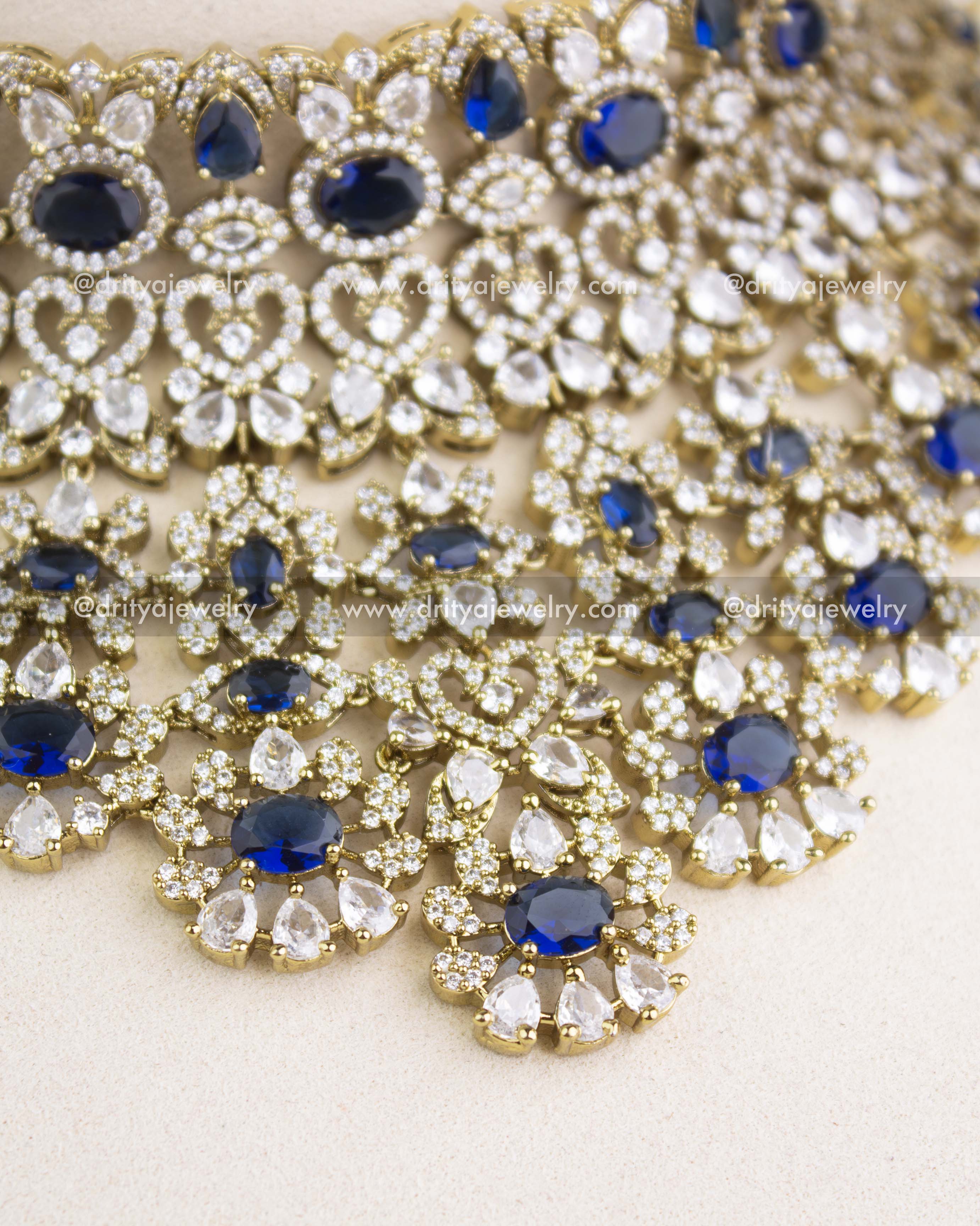 Close-up image of sapphire blue Victorian choker showcasing floral clusters, teardrop stones, and micro AD setting.