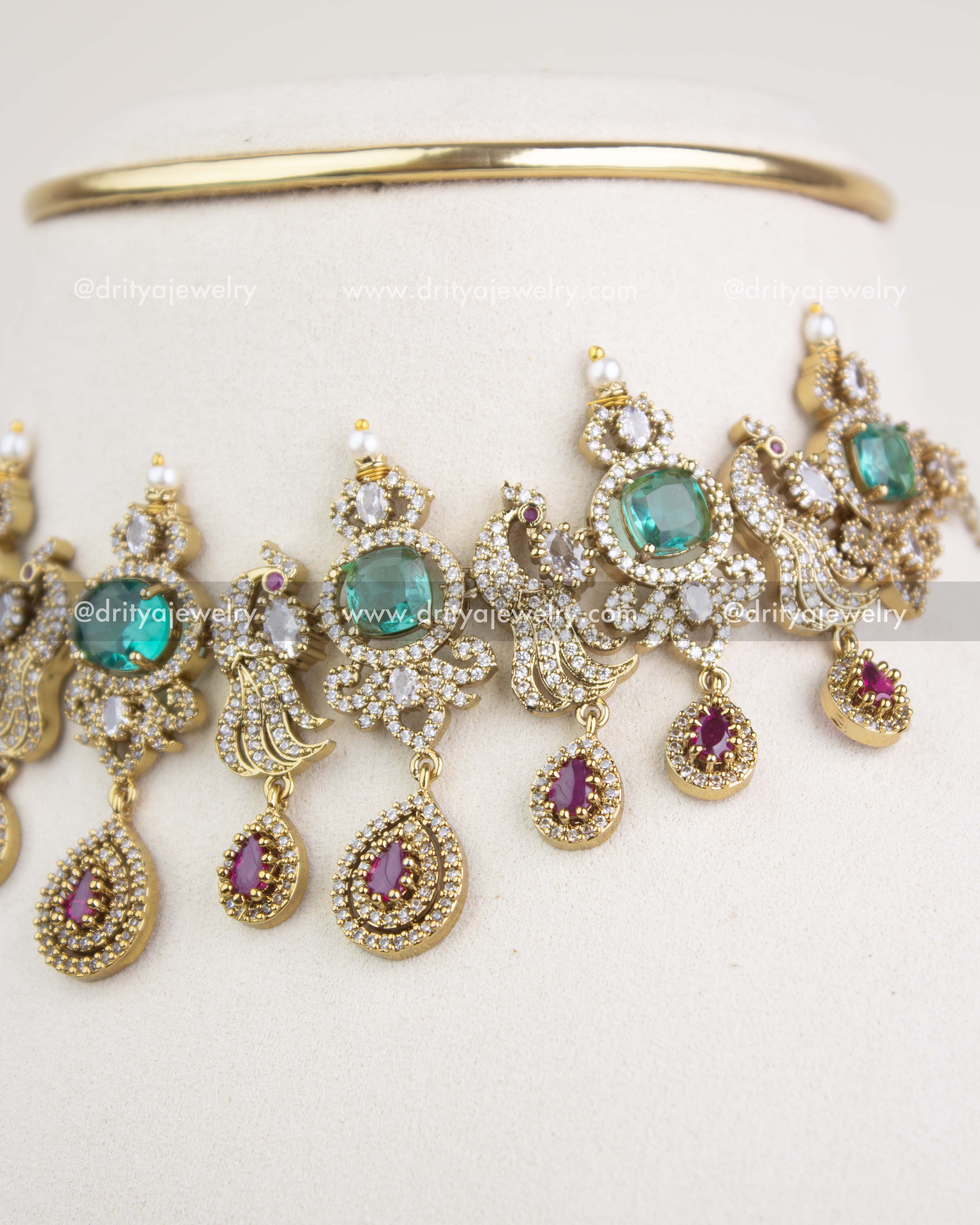 Detailed view of pear-shaped ruby drops, emerald clusters, and multi-layer Victorian motifs.