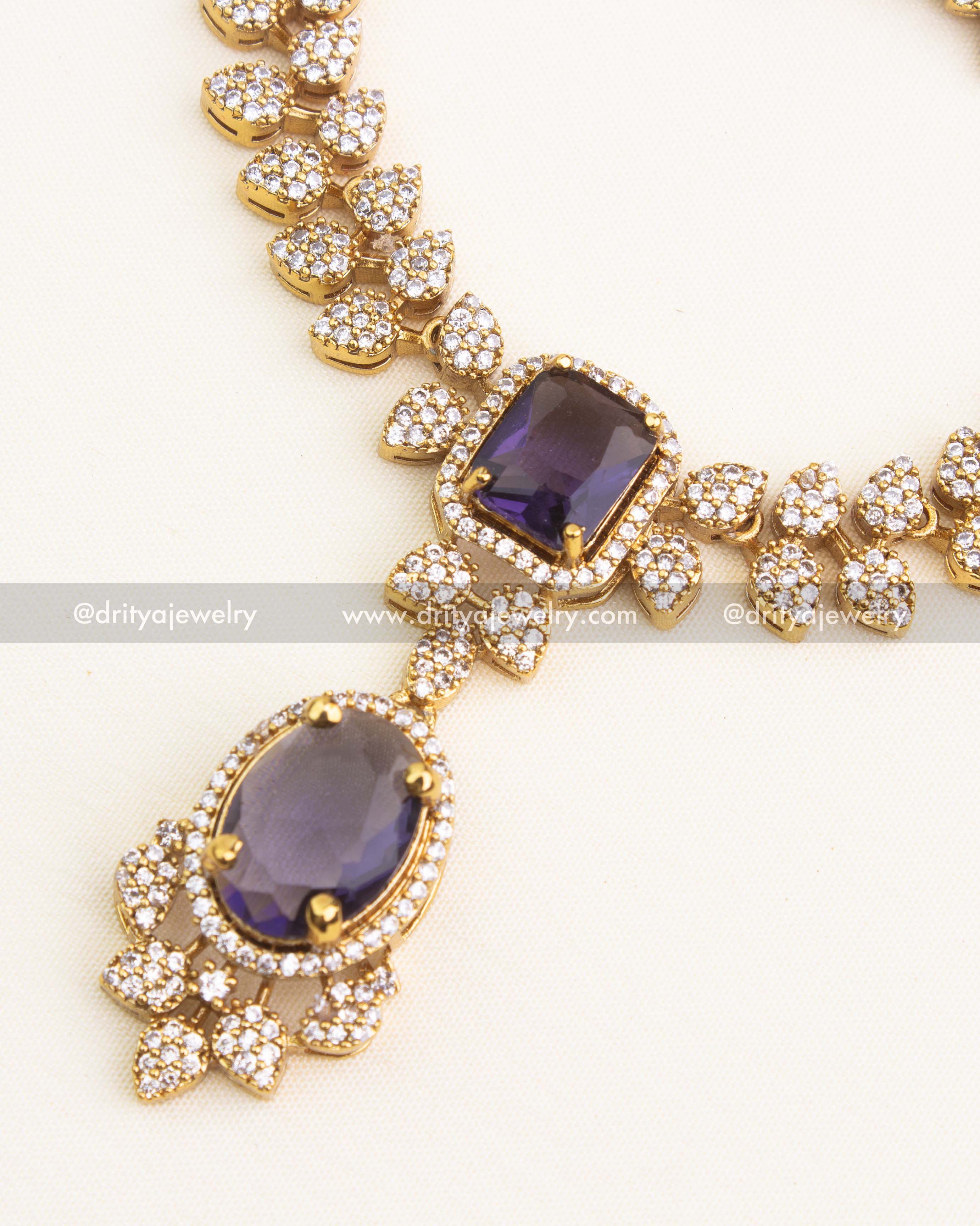 Close-up of purple pendant and cushion-cut CZ stone settings.