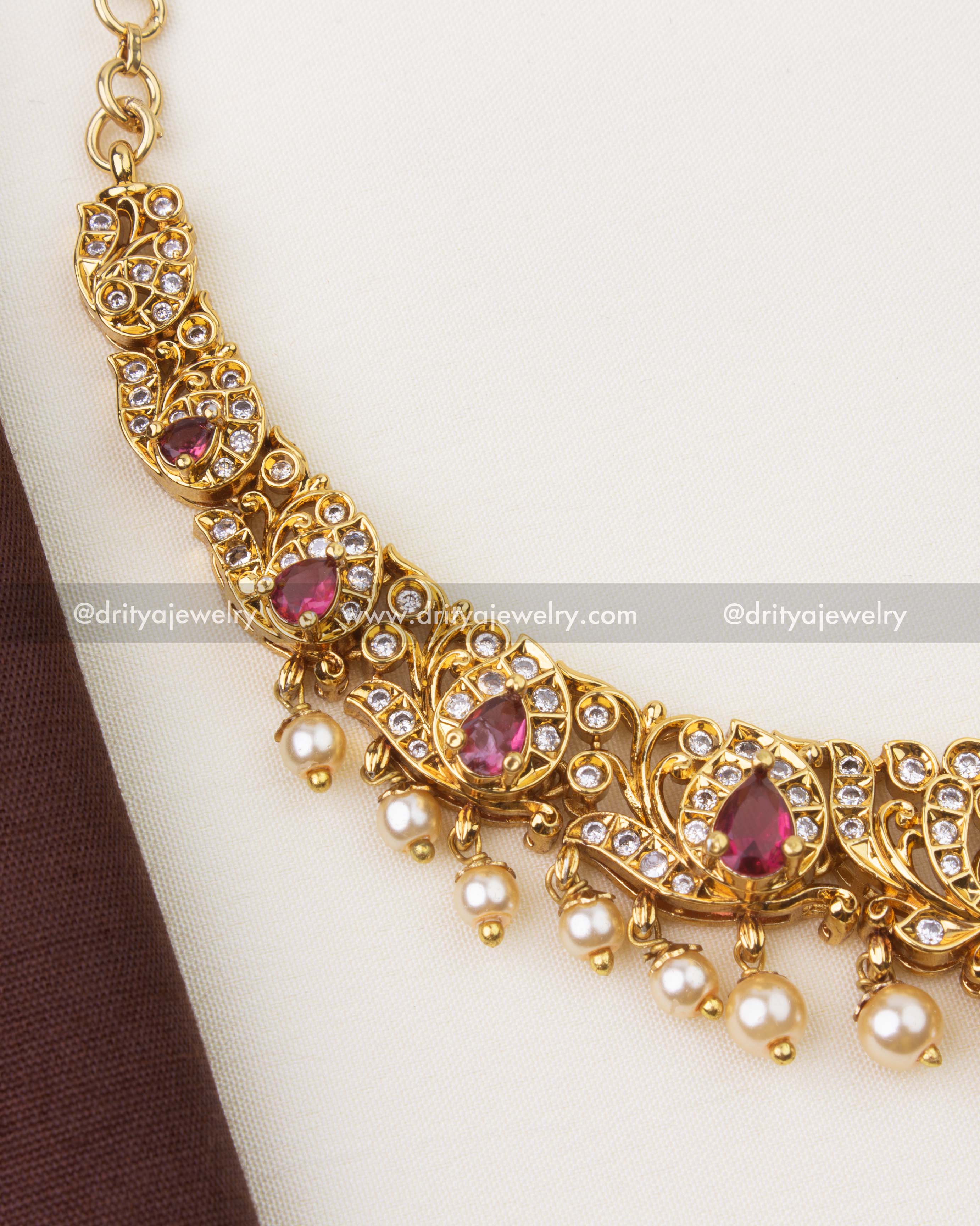 Close-up of Nakshi temple necklace with ruby red stones, CZ detailing and pearl hangings