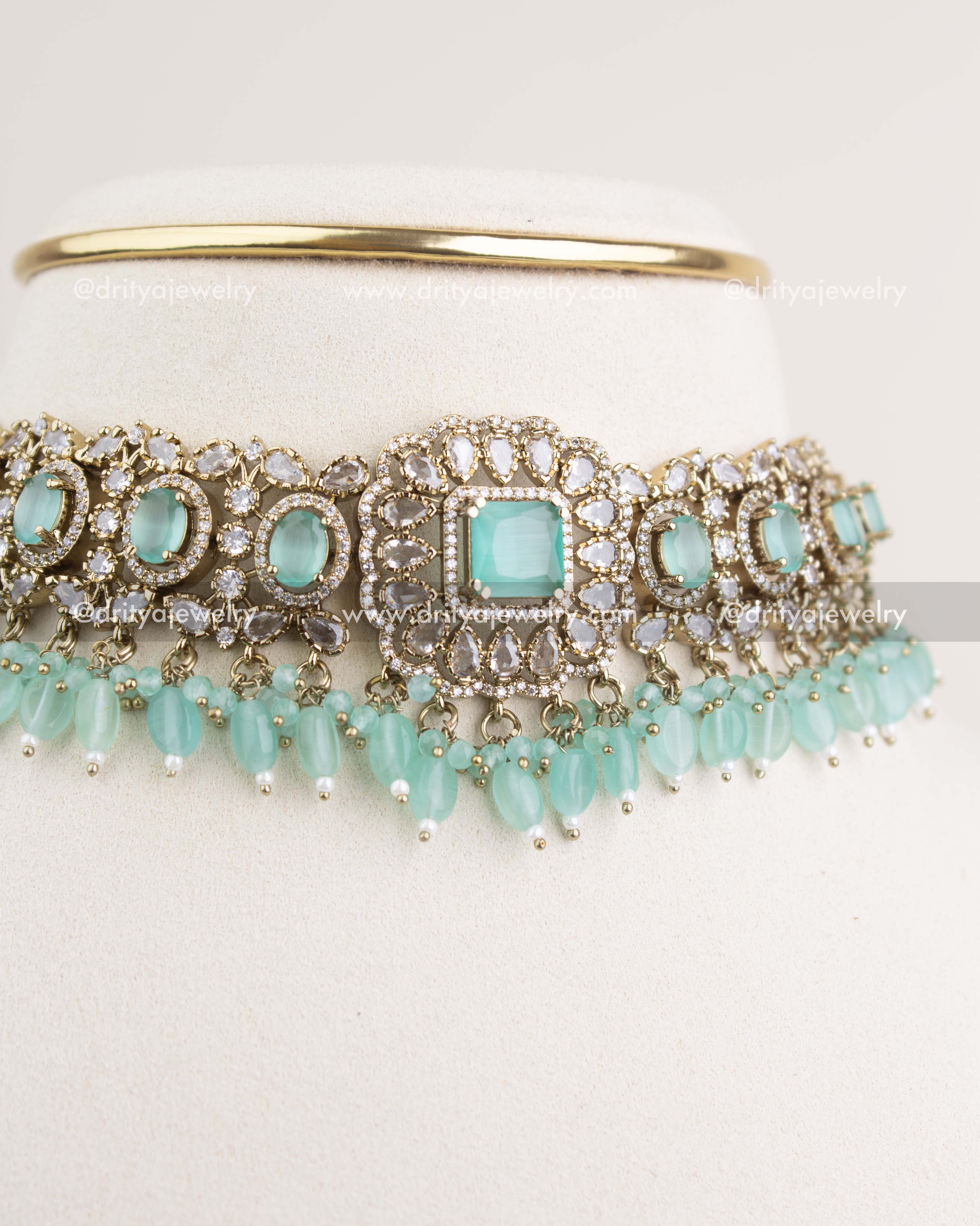 Close-up showing detailed Victorian motifs and mint central stone with CZ work.