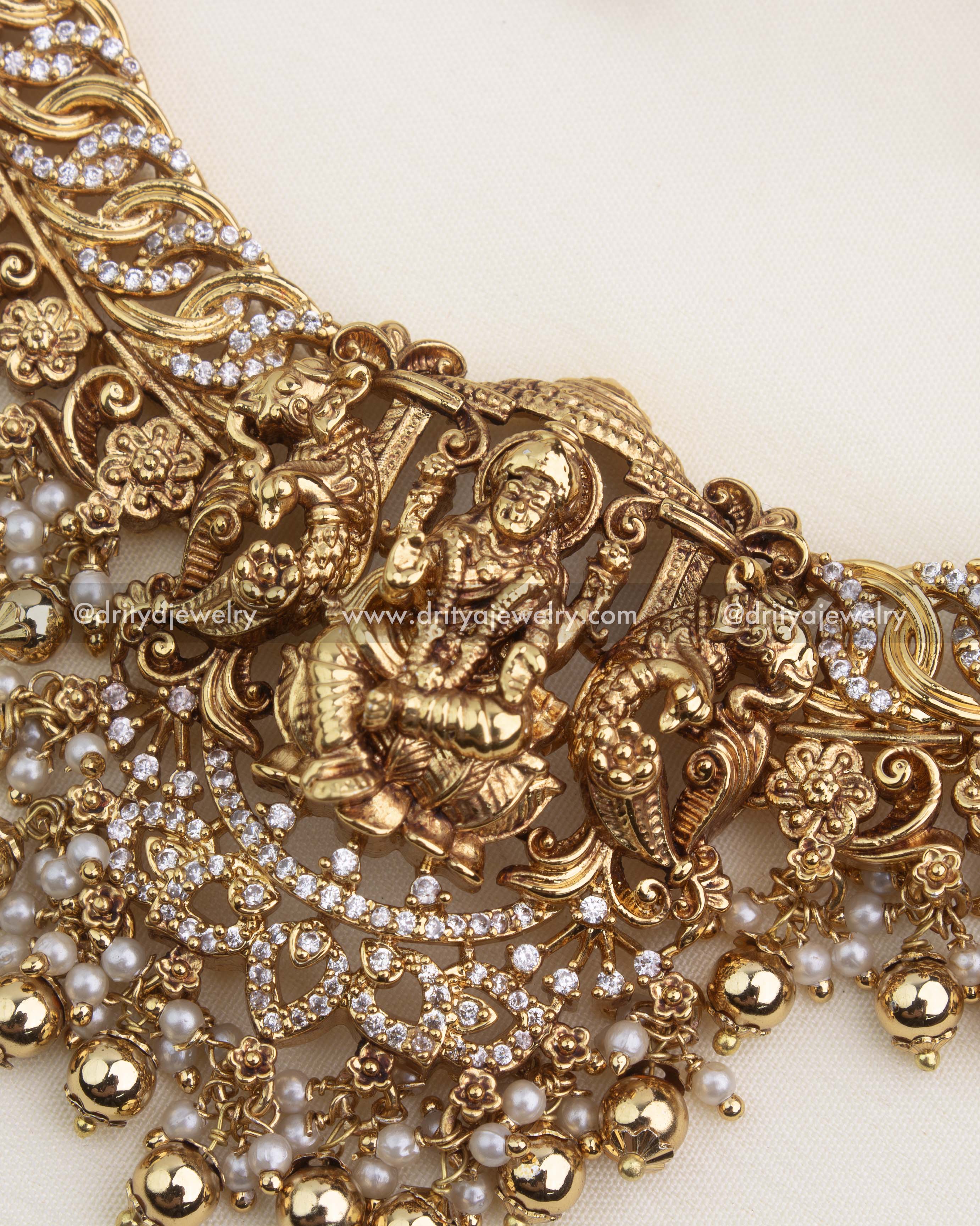 Detailed Lakshmi temple pendant with CZ stones, nakshi carving, and layered pearl-gold drops.