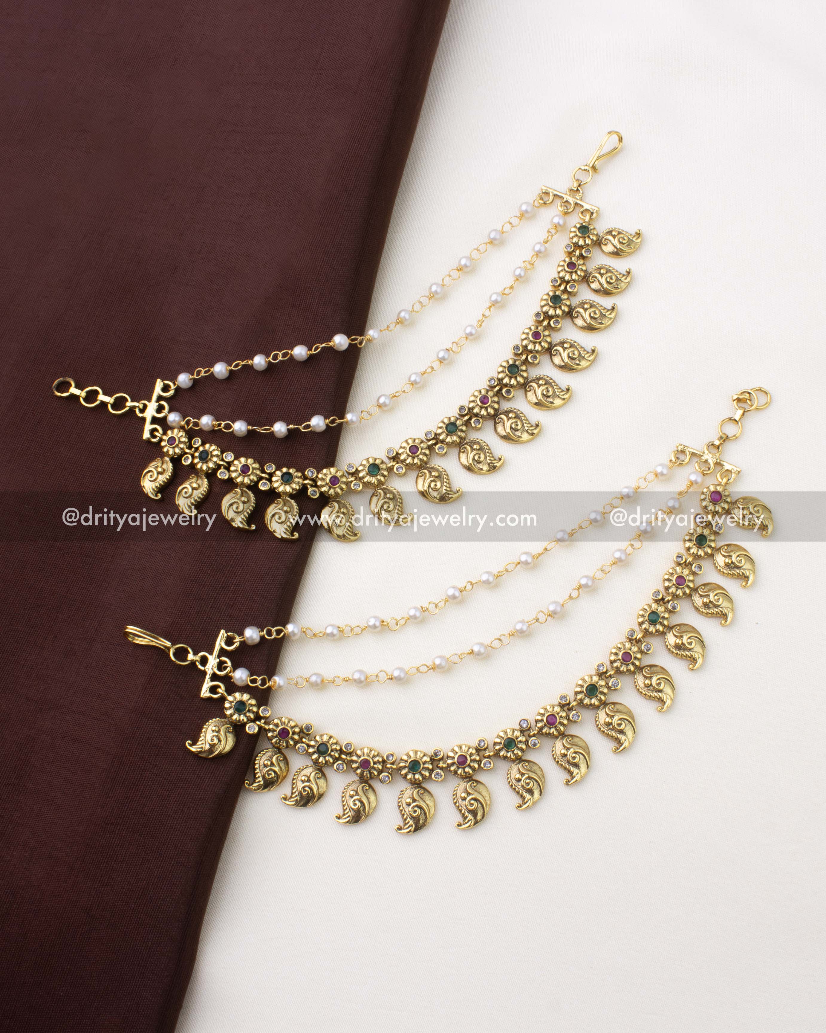 SKU 1294 pair of mango style champaswaralu with layered pearl chains laid on fabric