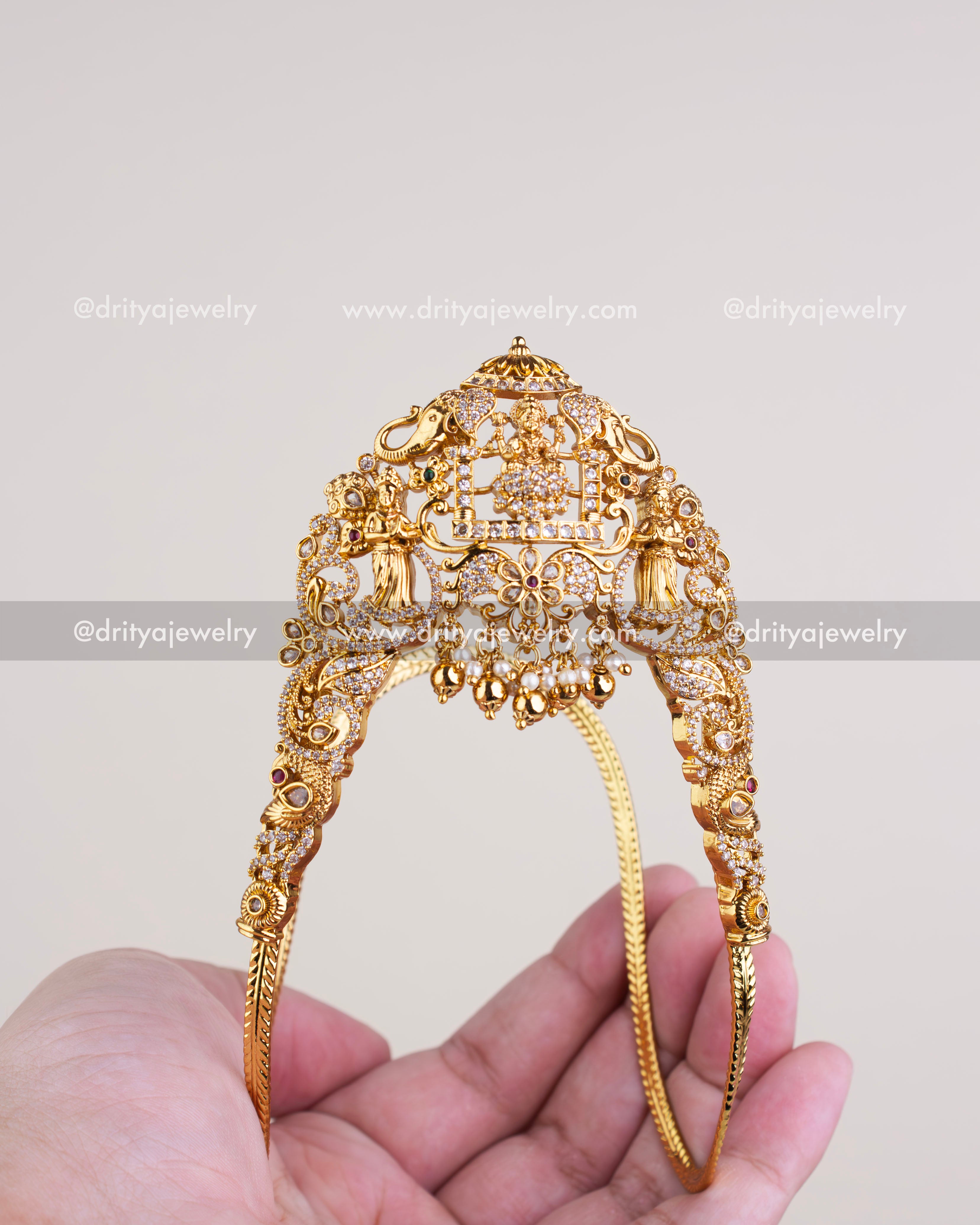 1126 - Front view of gold-toned temple vanki with god idol and stone work