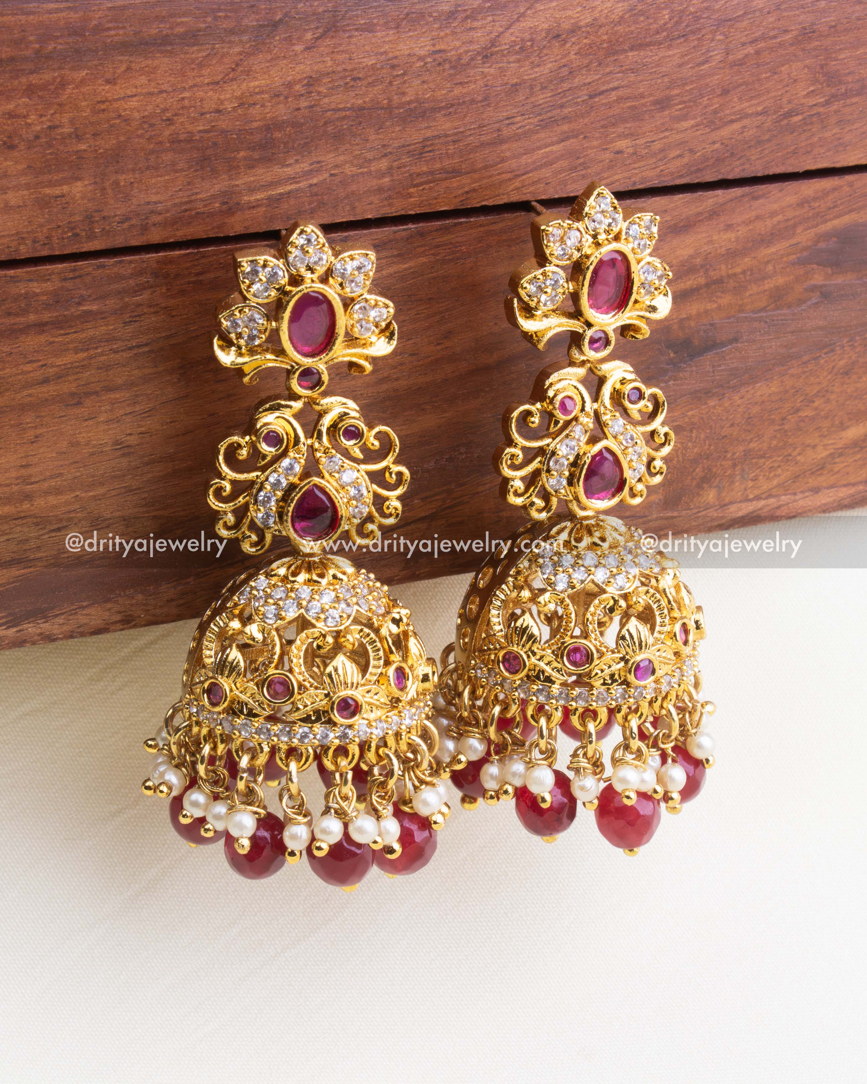 844-R - Earrings - Close front angle view of antique gold jhumka earrings with ruby stones and pearl drops