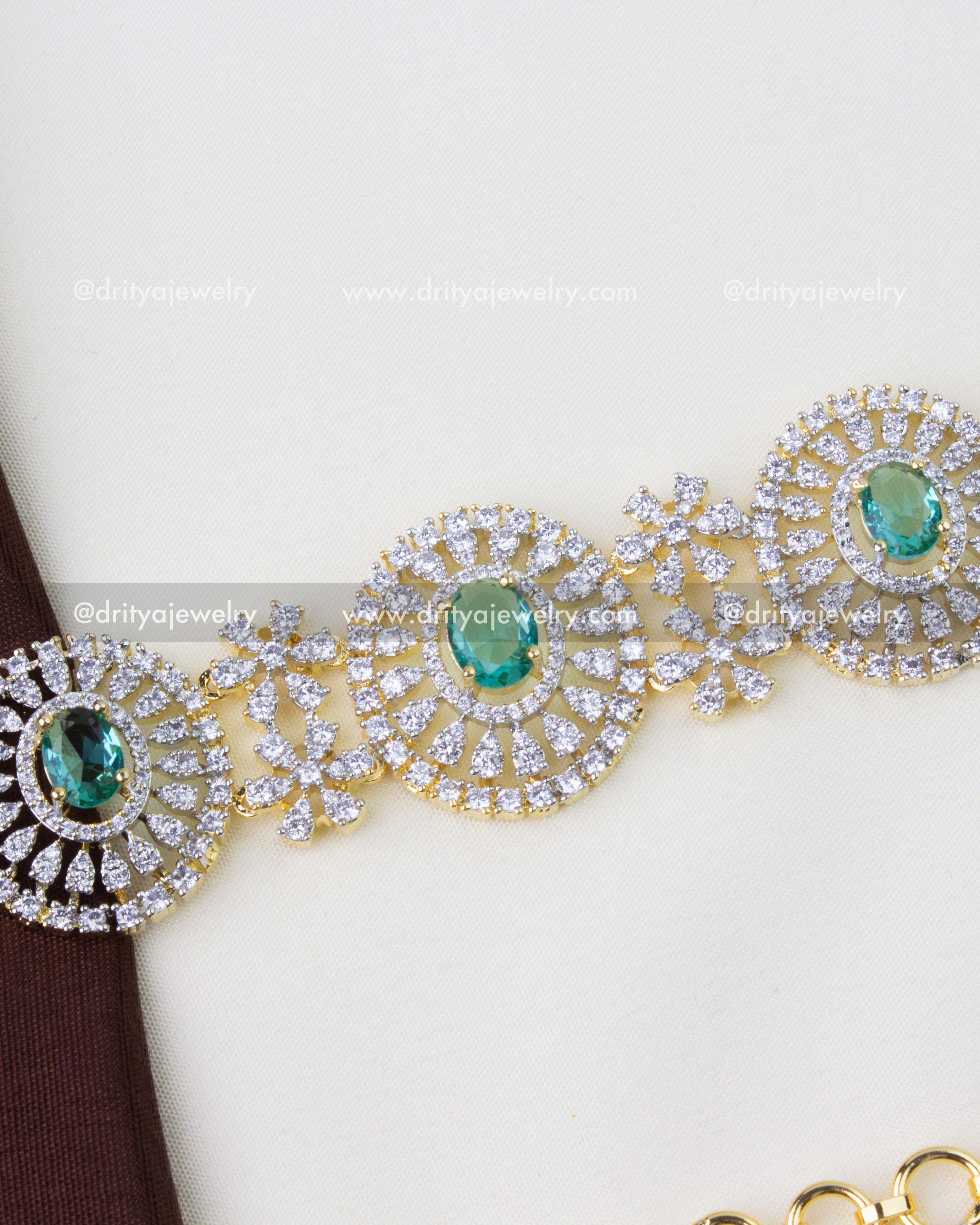 1291-RE premium diamond replica hip chain with emerald and CZ circular motifs close-up