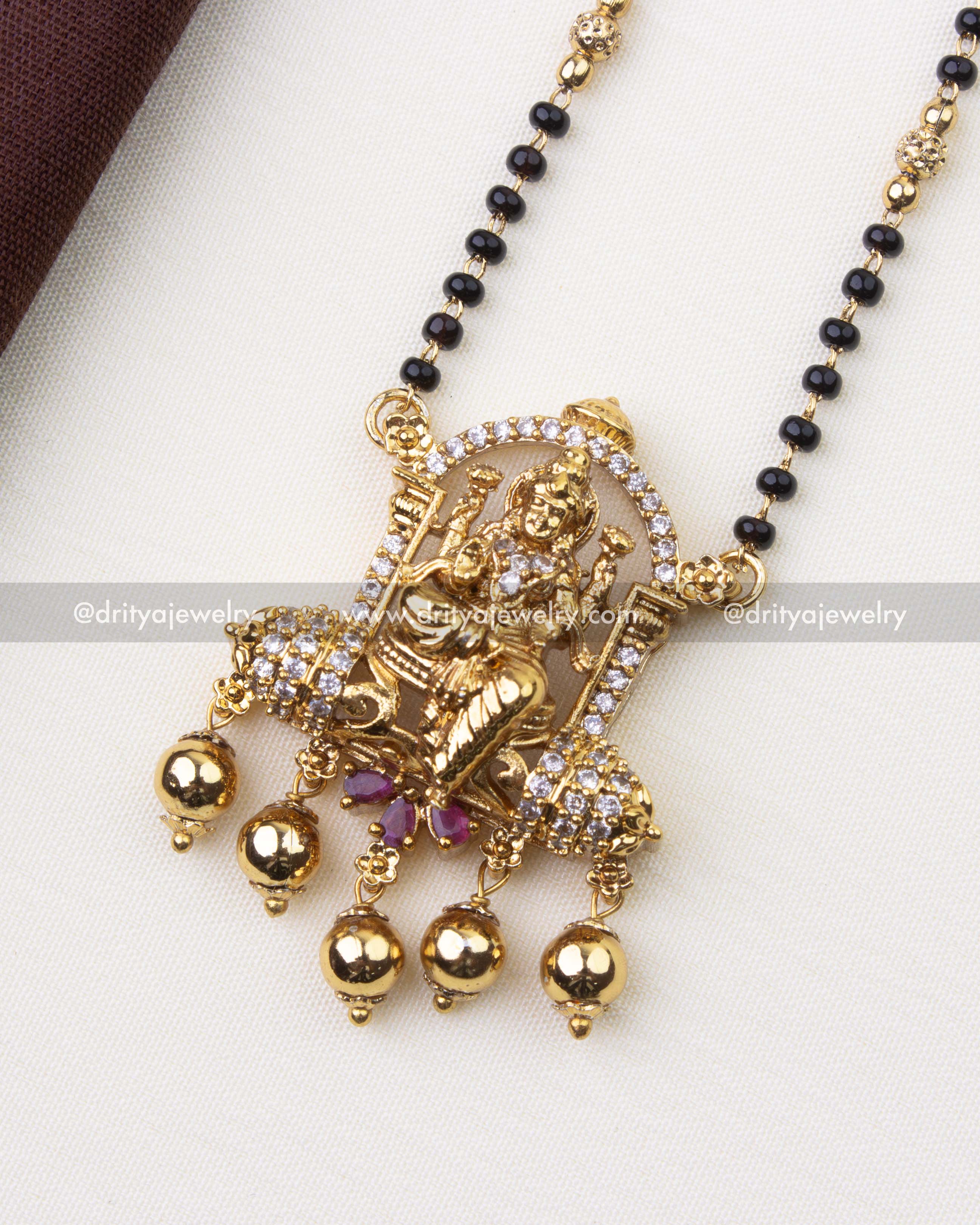 1222 - Close-up of god idol pendant with stone-studded arch and gold bead drops
