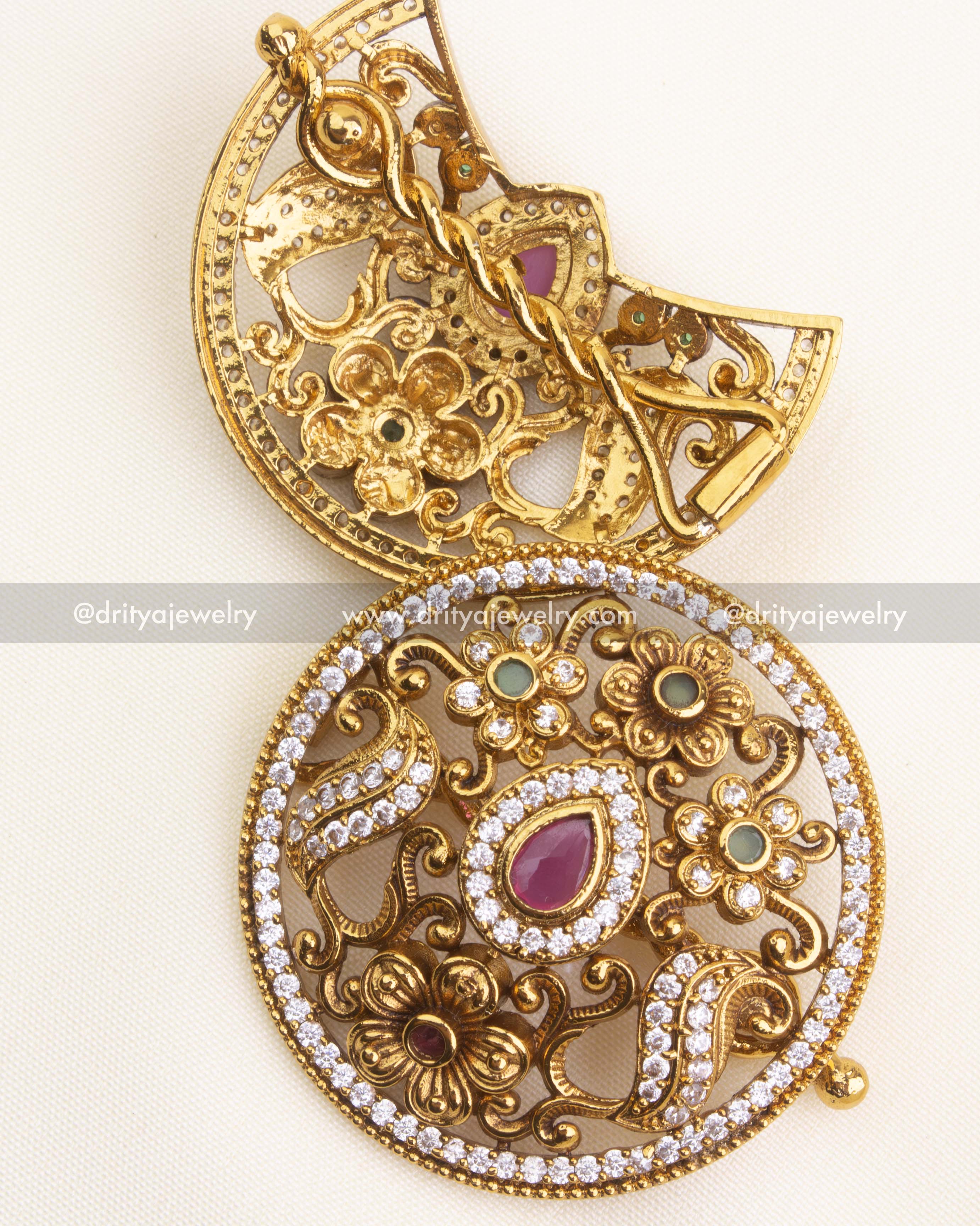 Antique gold sun and moon hair pins with floral and stone-studded detailing, close-up view of design and clasp.