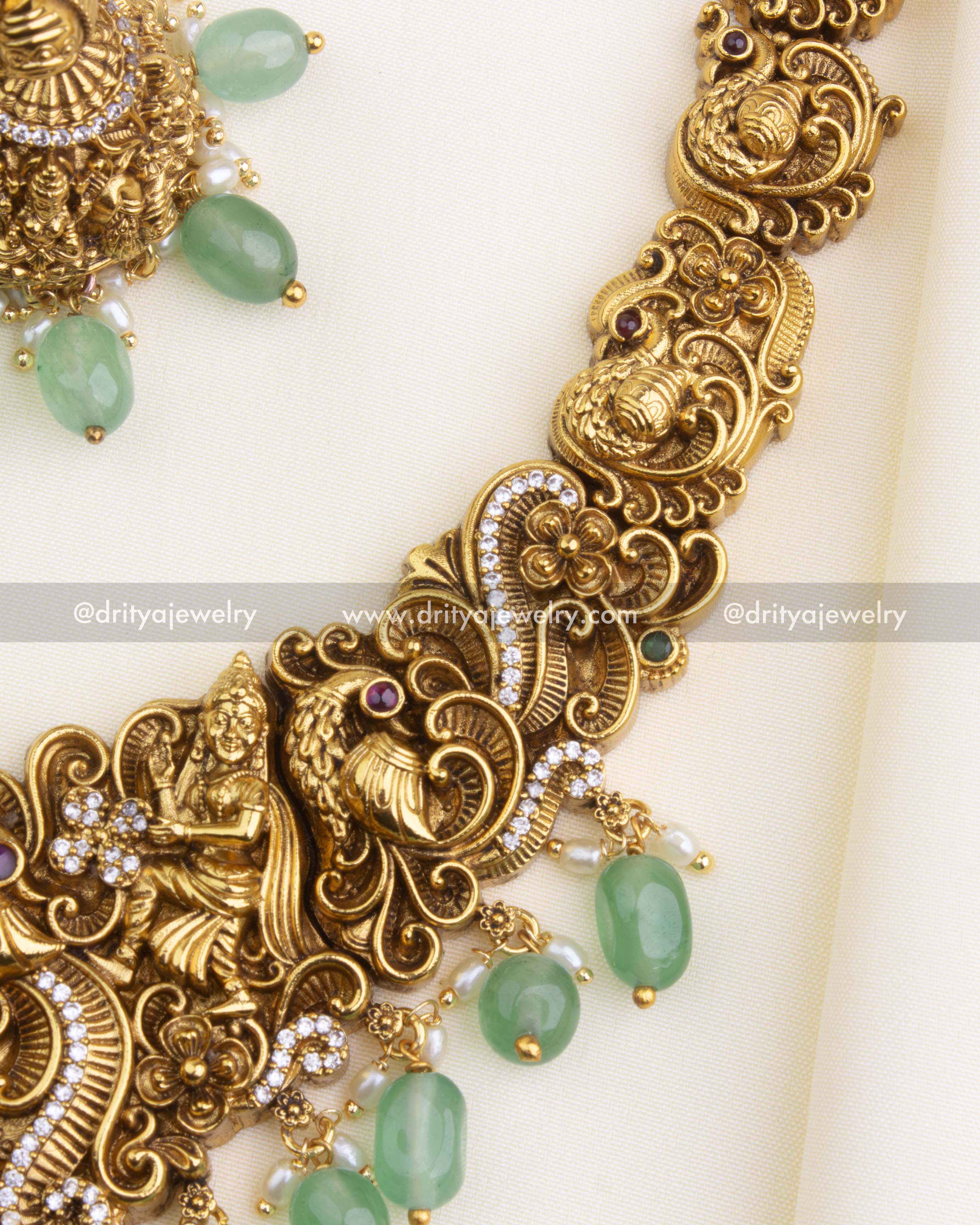 1195 - Detailed view of figurine motifs and peacock design on necklace