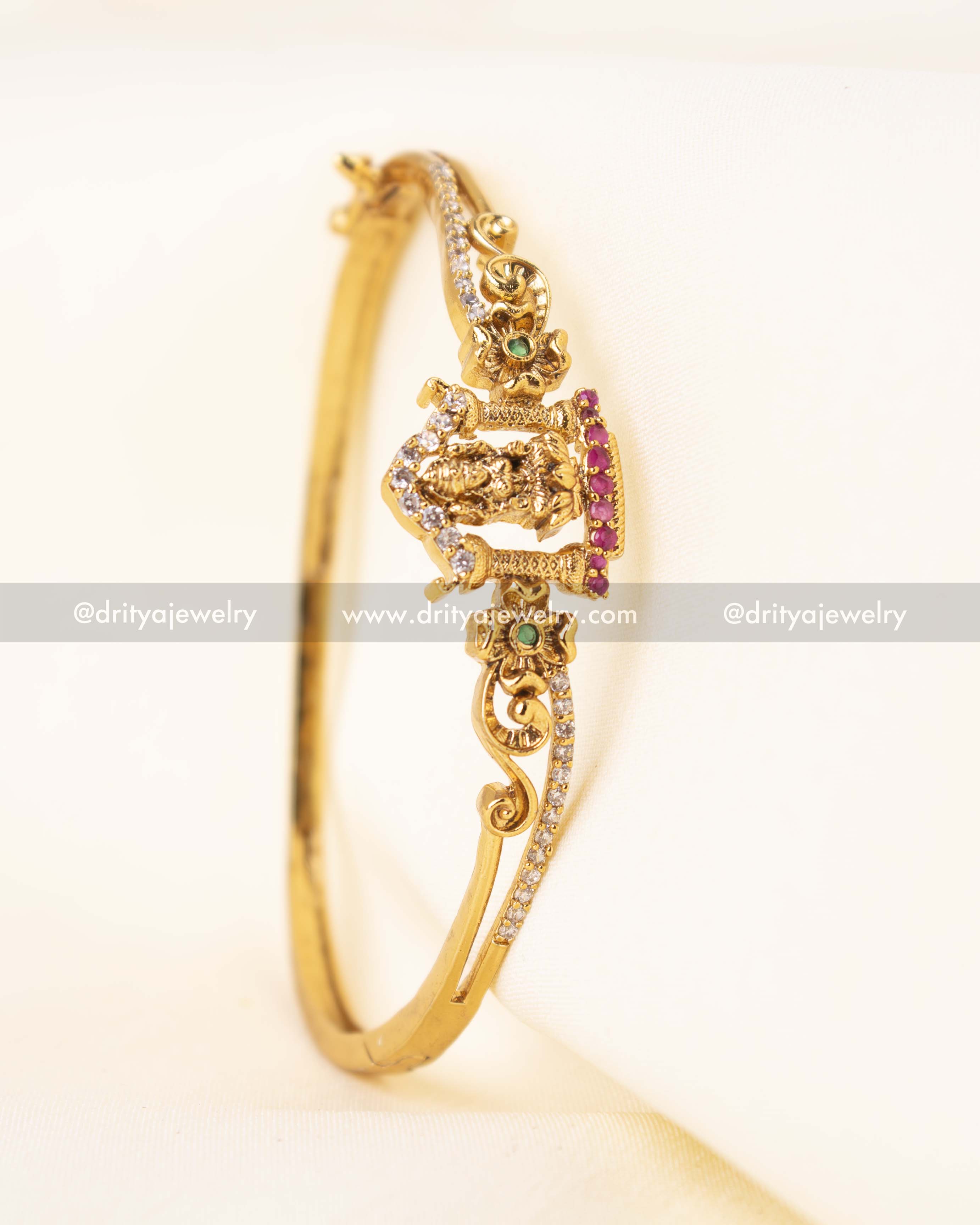Side profile of temple kada with intricate floral carvings and CZ detailing.