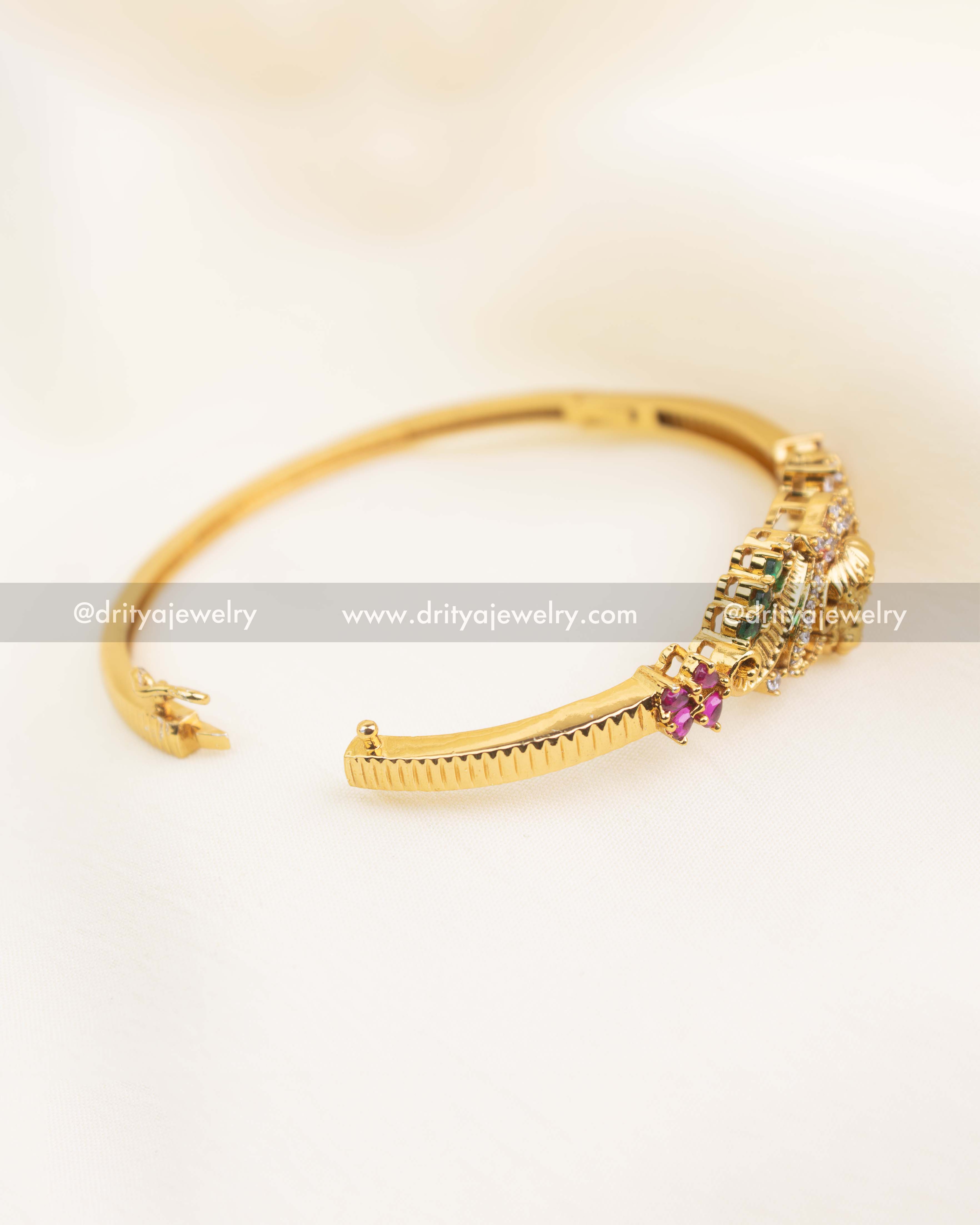 Close-up of openable temple kada showing hinge and detailed stone work.