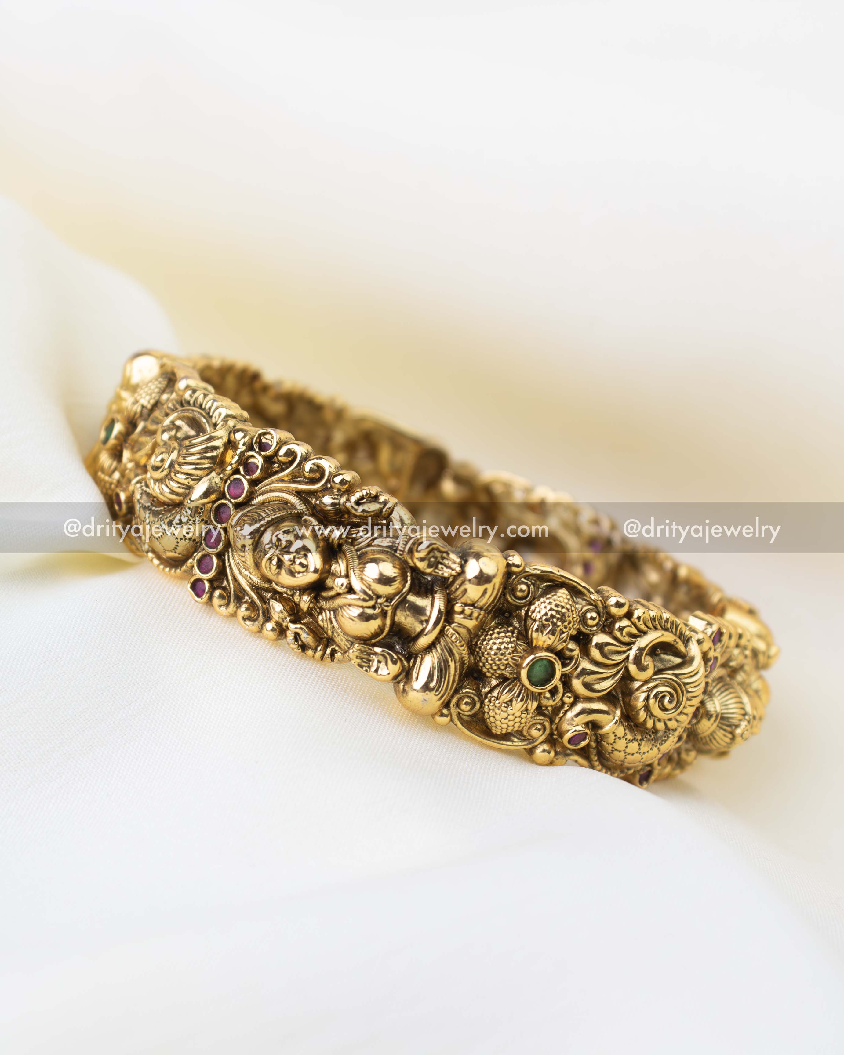 Traditional South Indian bridal kada bangles with peacock motifs and ruby green stone accents