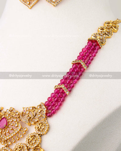 Back side detail of pink beaded necklace with gold-toned chain and stone-studded link.