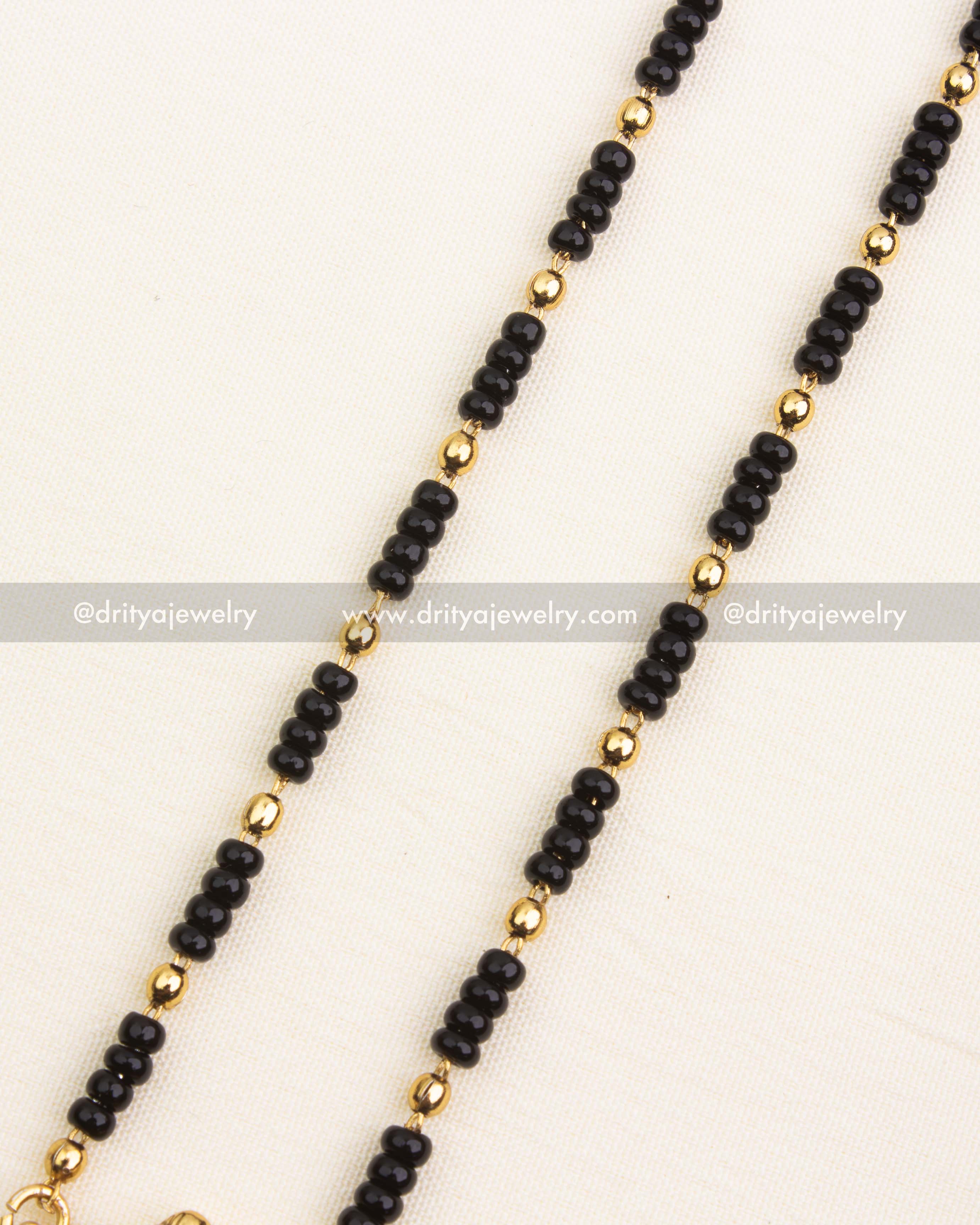 Detailed view of single-line black beads chain with golden bead separators, 18 inches long.