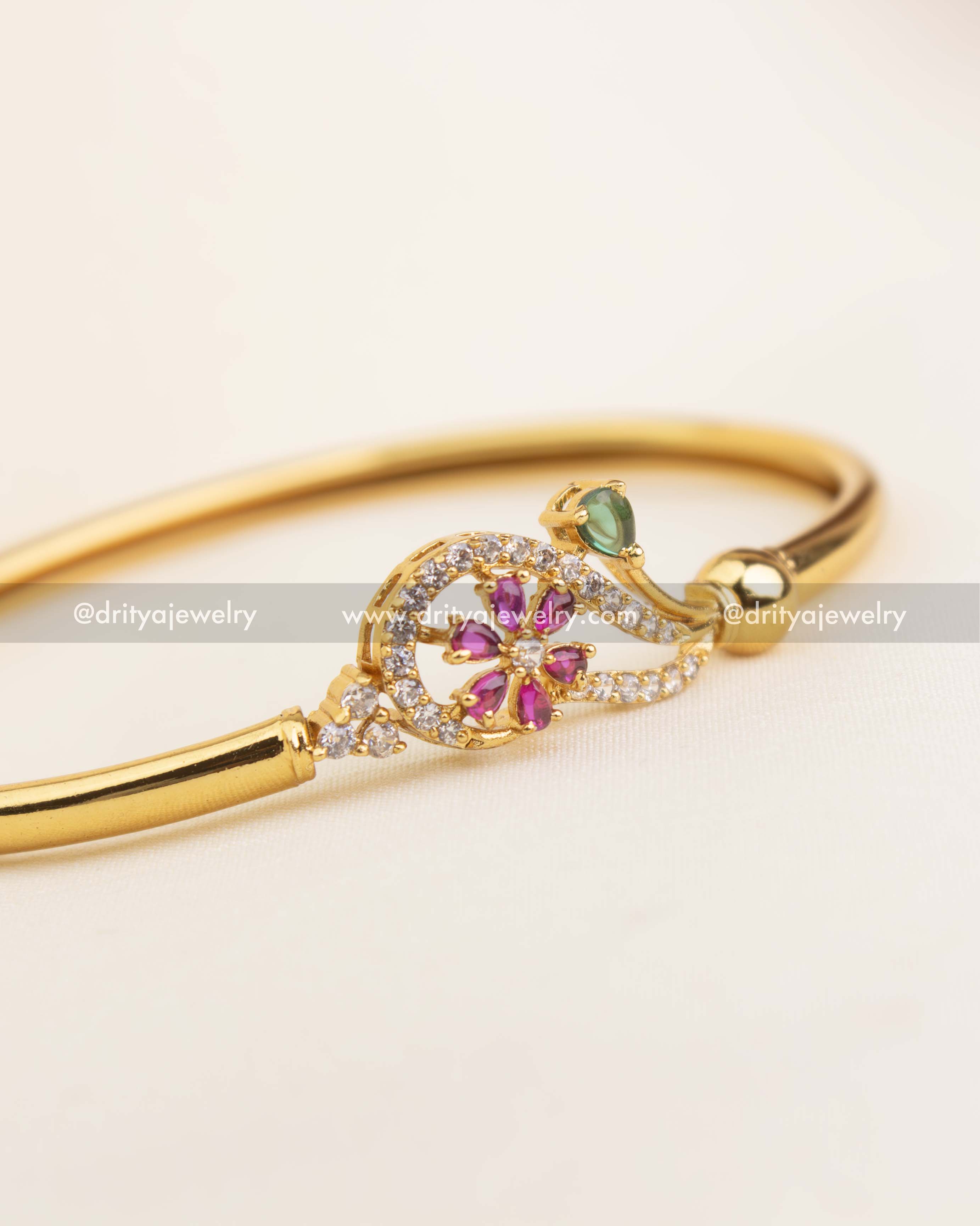 Gold-plated kada with pink floral center, green stone leaf, and American Diamond accents