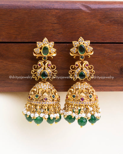 Temple-style jhumkas with antique gold finish, green bead drops, and pearl accents – no god idol.
