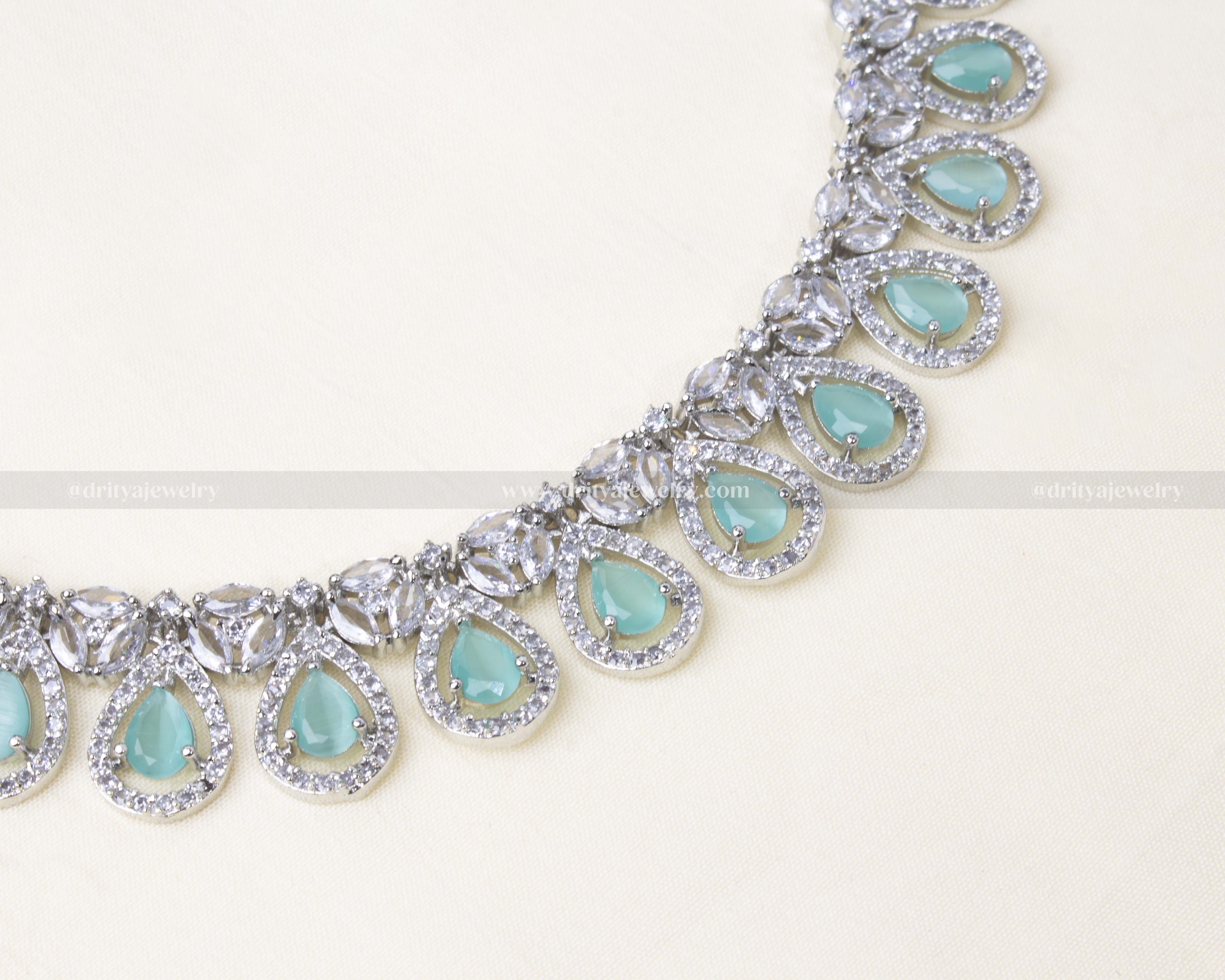 Elegant zircon short necklace set with aqua blue teardrop stones and AD embellishments, paired with matching drop earrings.