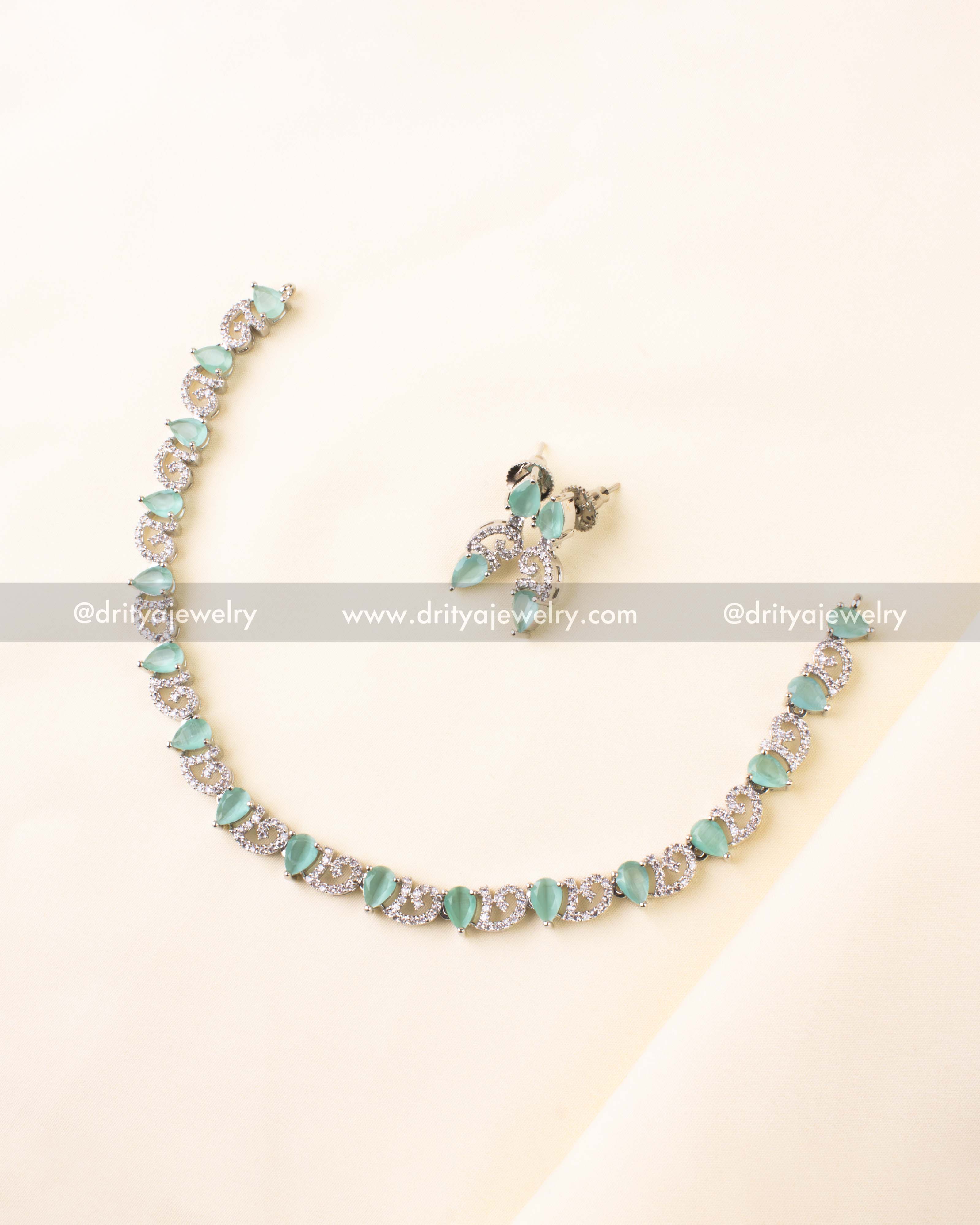 Silver-plated necklace set with aqua blue pear stones and dazzling CZ detailing.
