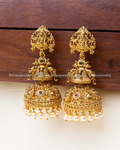 Premium big size temple Jhumka earrings with goddess Lakshmi design and pearl drops.