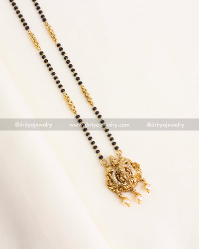 Traditional necklace with dual black bead strands and Lakshmi Devi gold pendant with pearl drops.