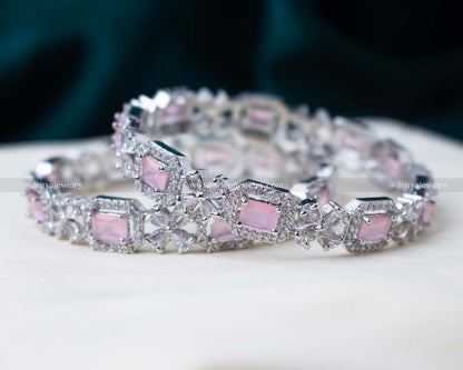 Pair of zircon bangles featuring blush pink gemstones and American Diamond embellishments in a silver-tone finish.