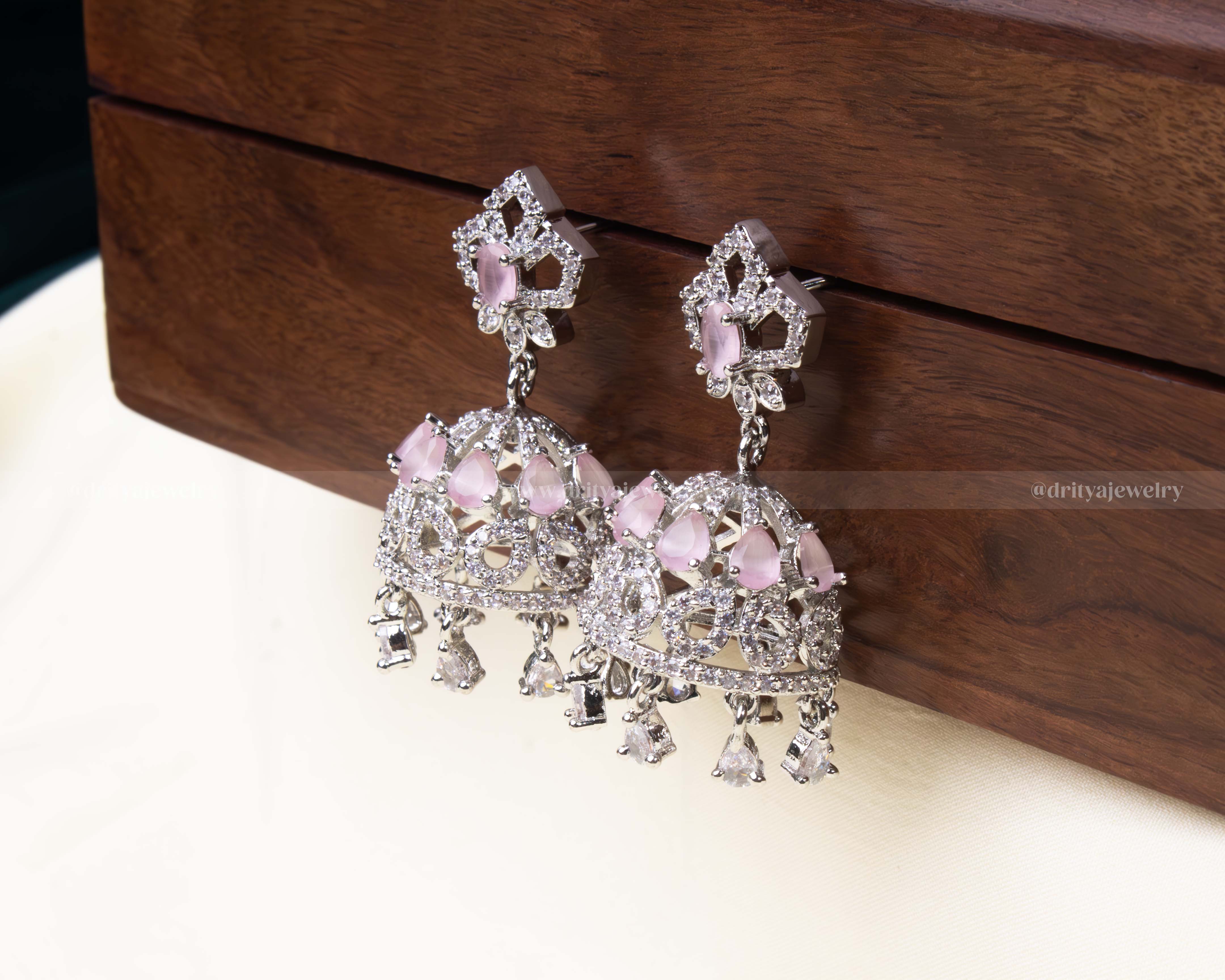 Blush pink zircon Jhumka earrings featuring intricate detailing and teardrop danglers.