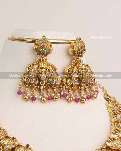 Temple jhumka earrings adorned with CZ stones and ruby pink bead hangings.