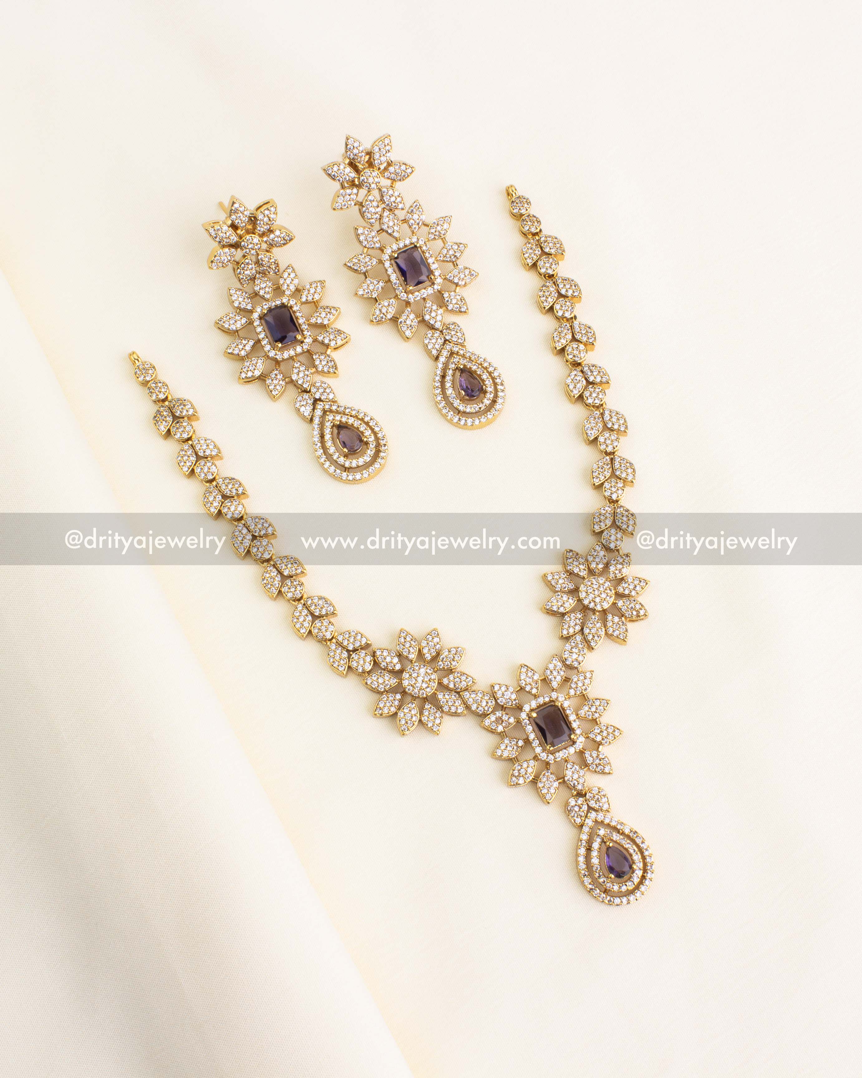 Purple and gold floral necklace set with cubic zirconia and drop detailing.