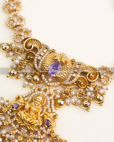 Close-up of Lakshmi pendant with CZ detailing, purple gemstone, and pearl-gold droplet clusters
