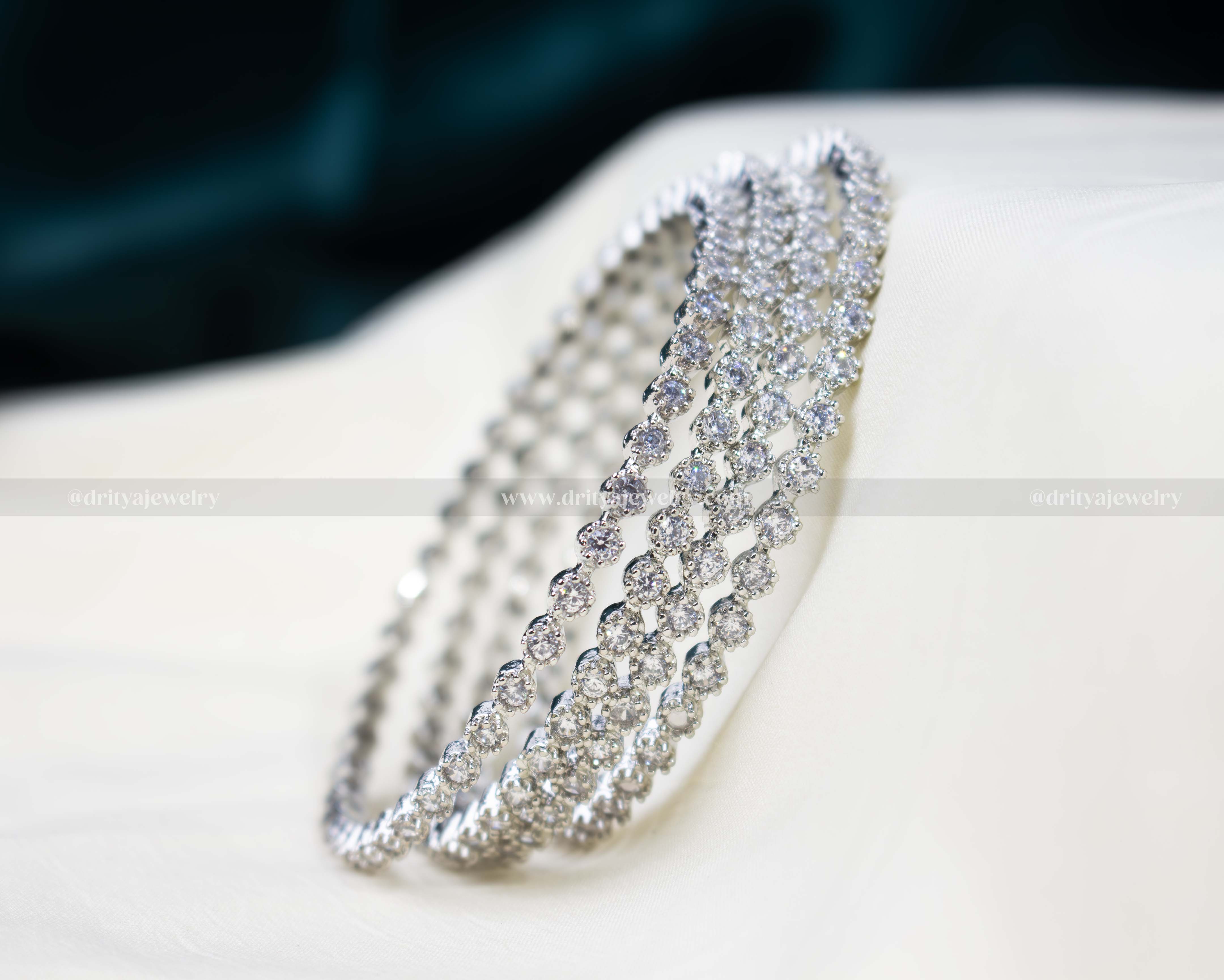 Set of four CZ zircon stone bangles with a silver-tone finish, featuring intricately placed sparkling stones, perfect for festive and daily wear.