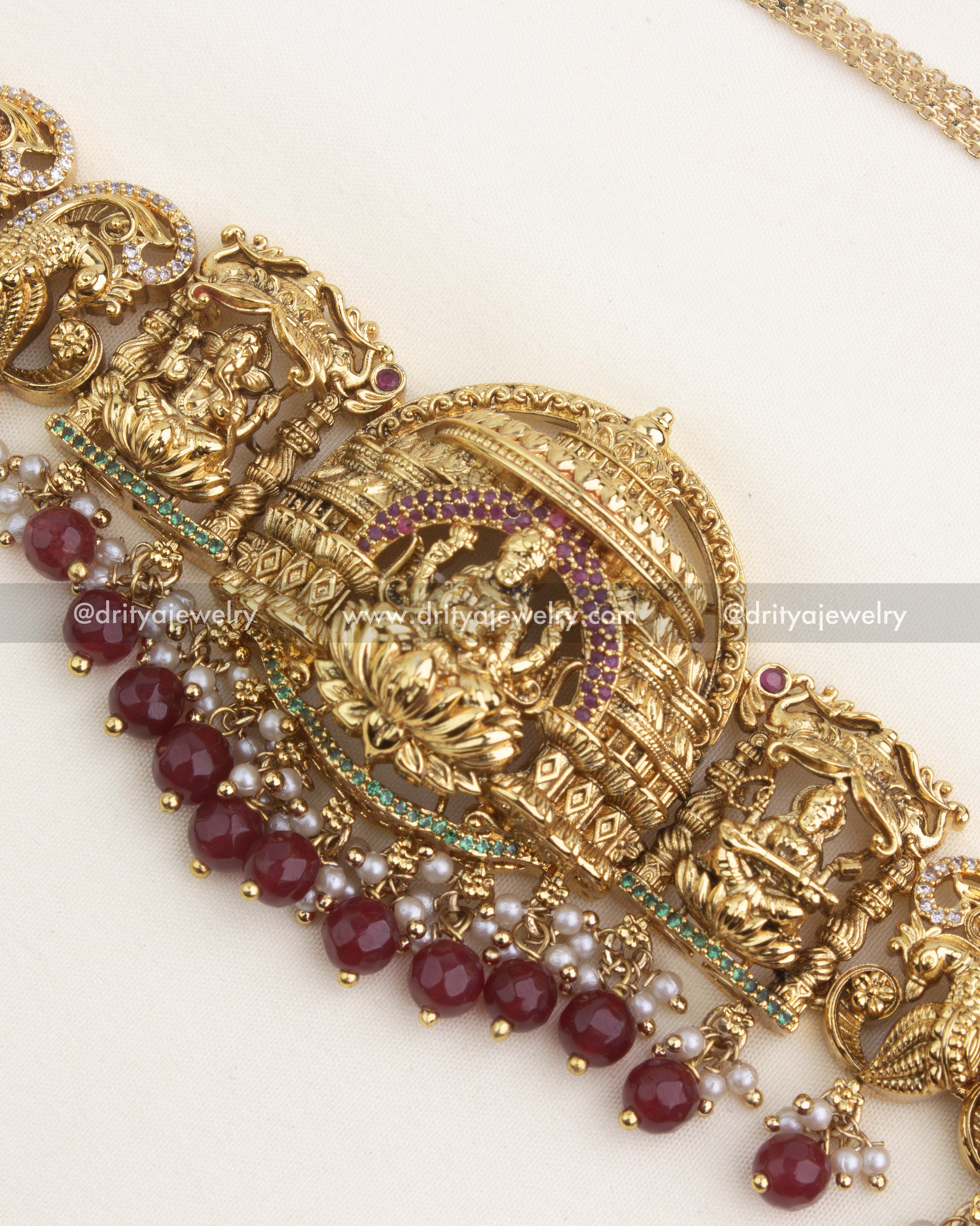 Antique temple Lakshmi pendant with ruby accent stones and red bead hangings.