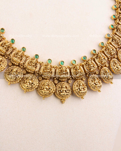 Symmetrical layout of Lakshmi coins with traditional Nakshi gold finish and gemstone highlights.