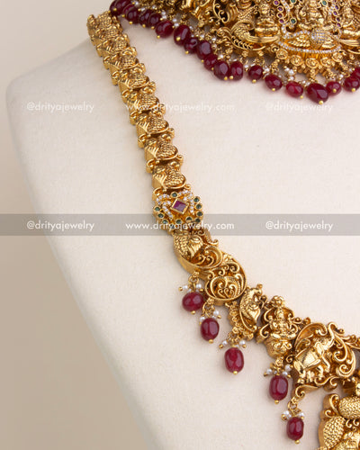 Gold-plated temple jewelry chain with engraved elephant and ruby accents.