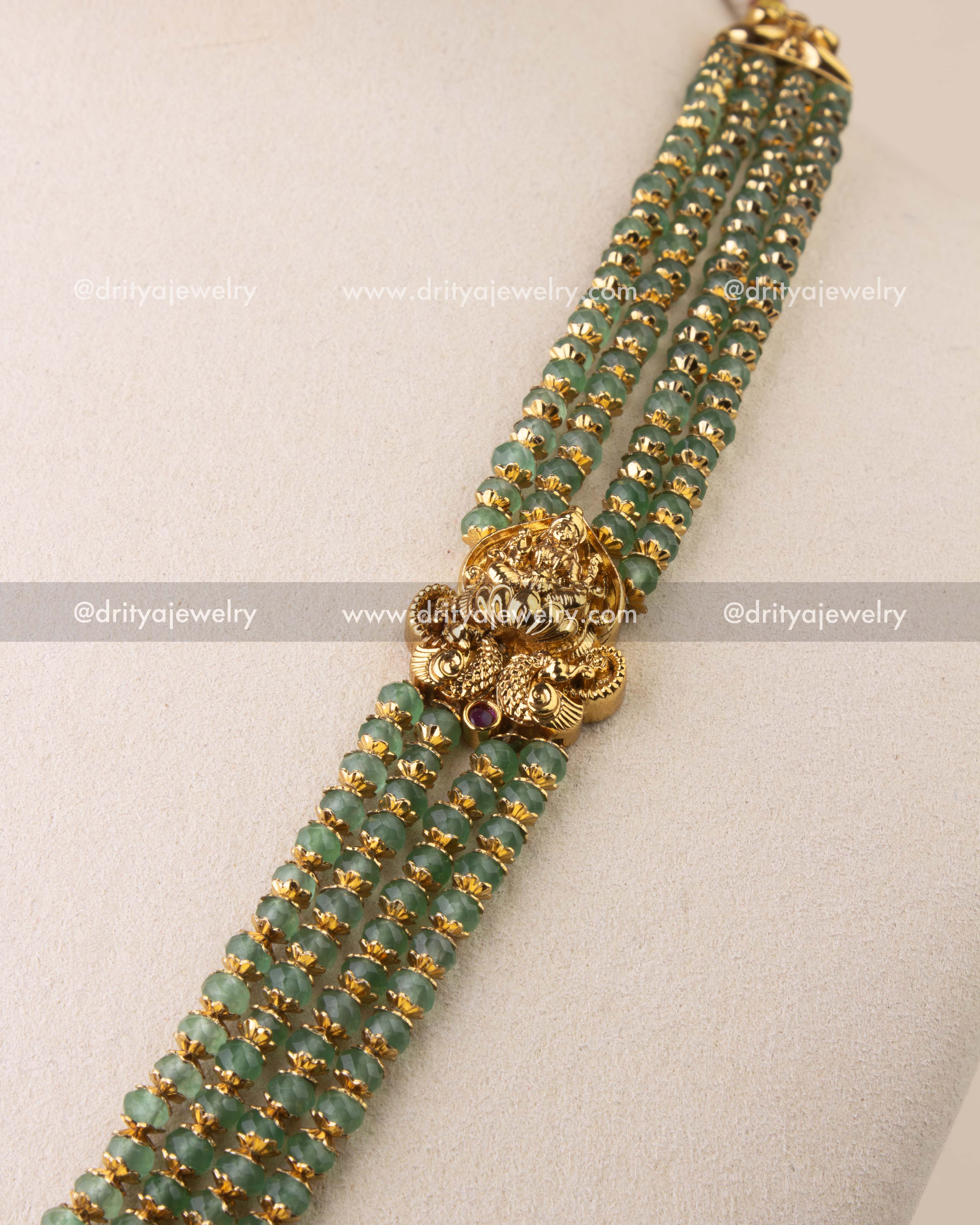 Multi-strand green beads with antique Nakshi detailing.