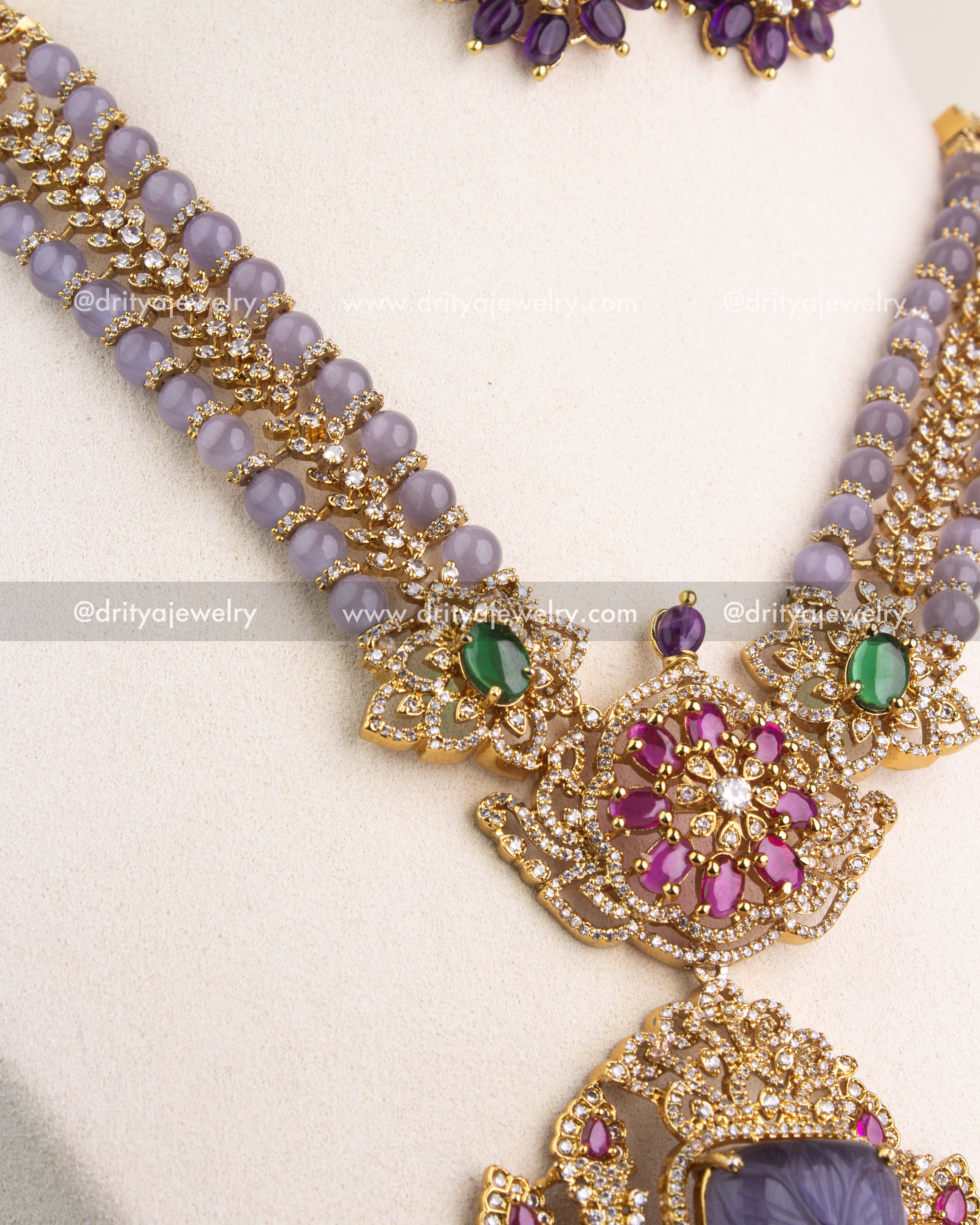 Dual lavender bead chain with crystal highlights and green gemstone connectors.