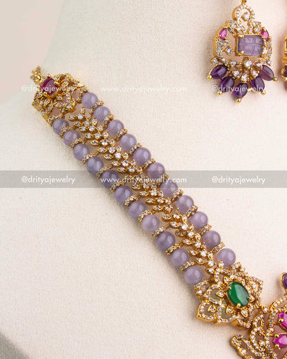 Dual lavender bead chain with crystal highlights and green gemstone connectors.