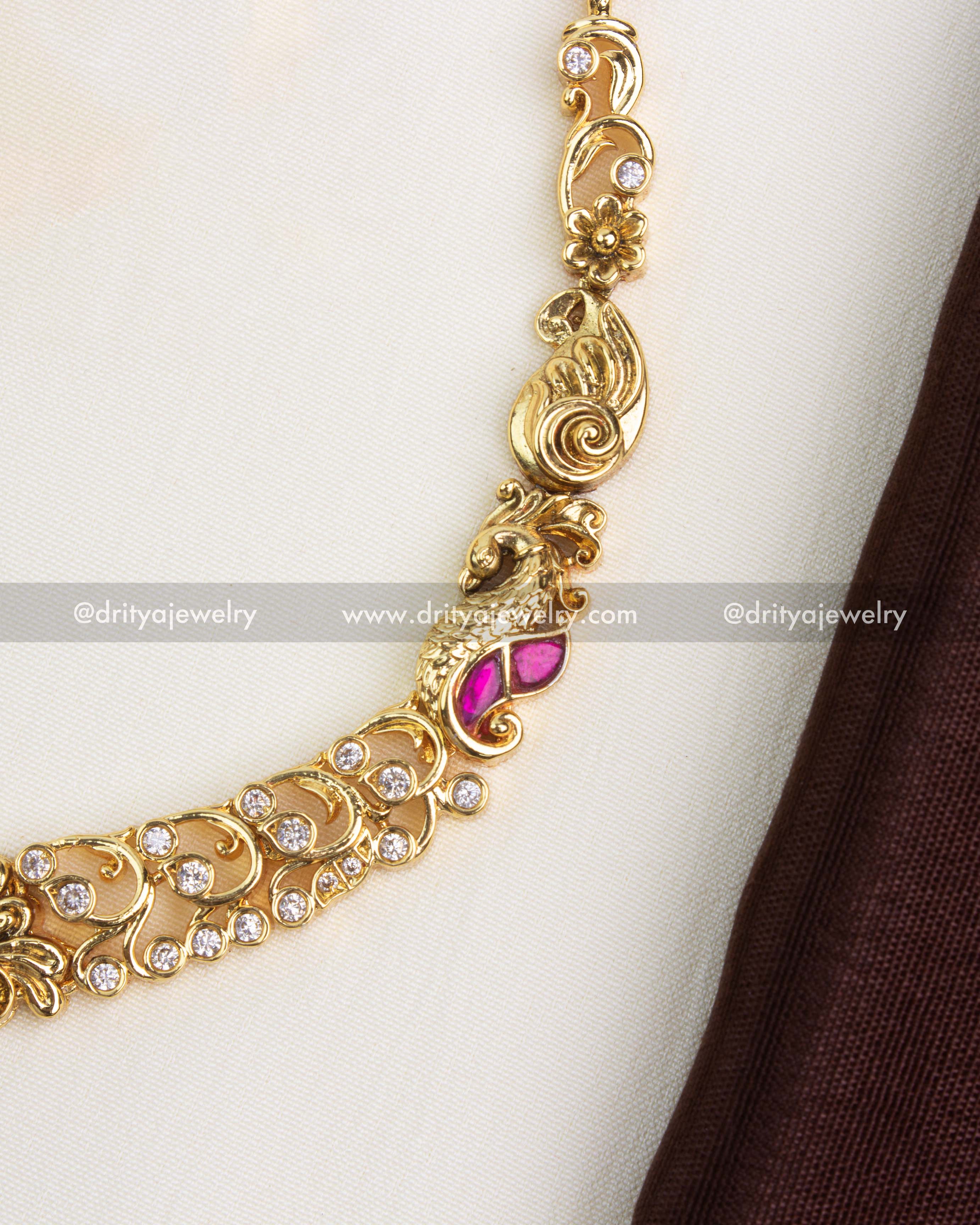 Detailed view of peacock links and floral scrolls with AD stone accents along the chain of the Nakshi necklace.