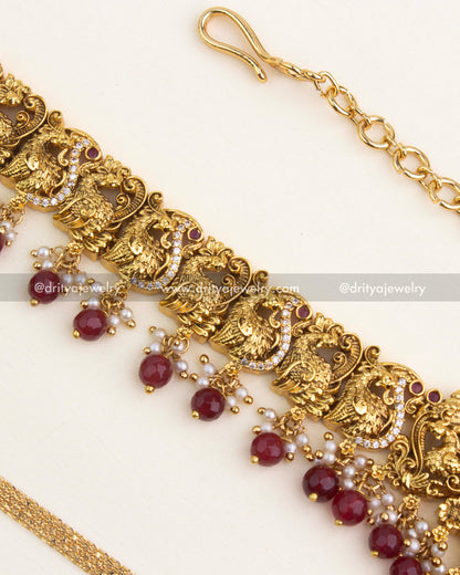 Peacock nakshi carvings decorated with ruby accents and sparkling CZ stonework.