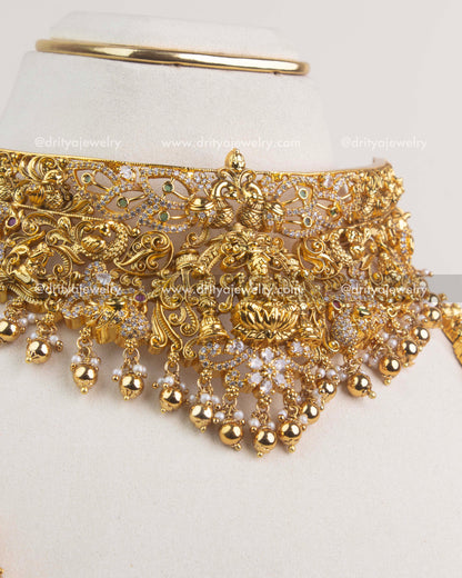 Antique gold temple choker with Lakshmi design, floral patterns, and pearl bead drops.