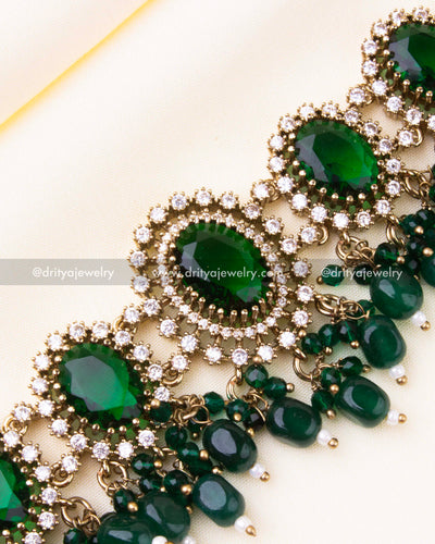 Detailed close-up of emerald green choker with drop beads and white stones