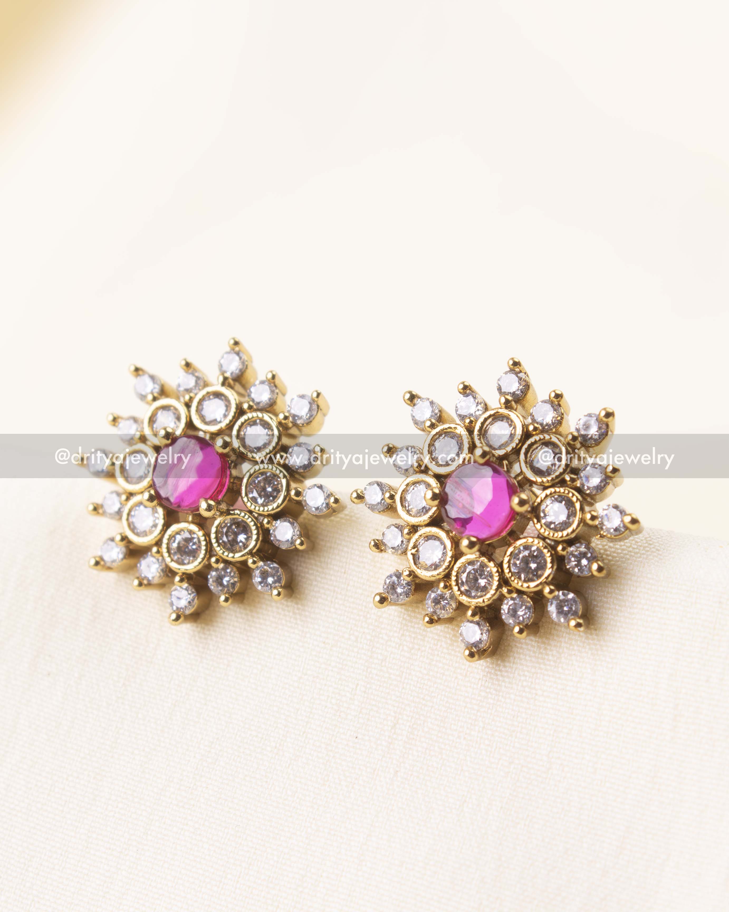Elegant gold-plated stud earrings with a pink center stone and crystal border.