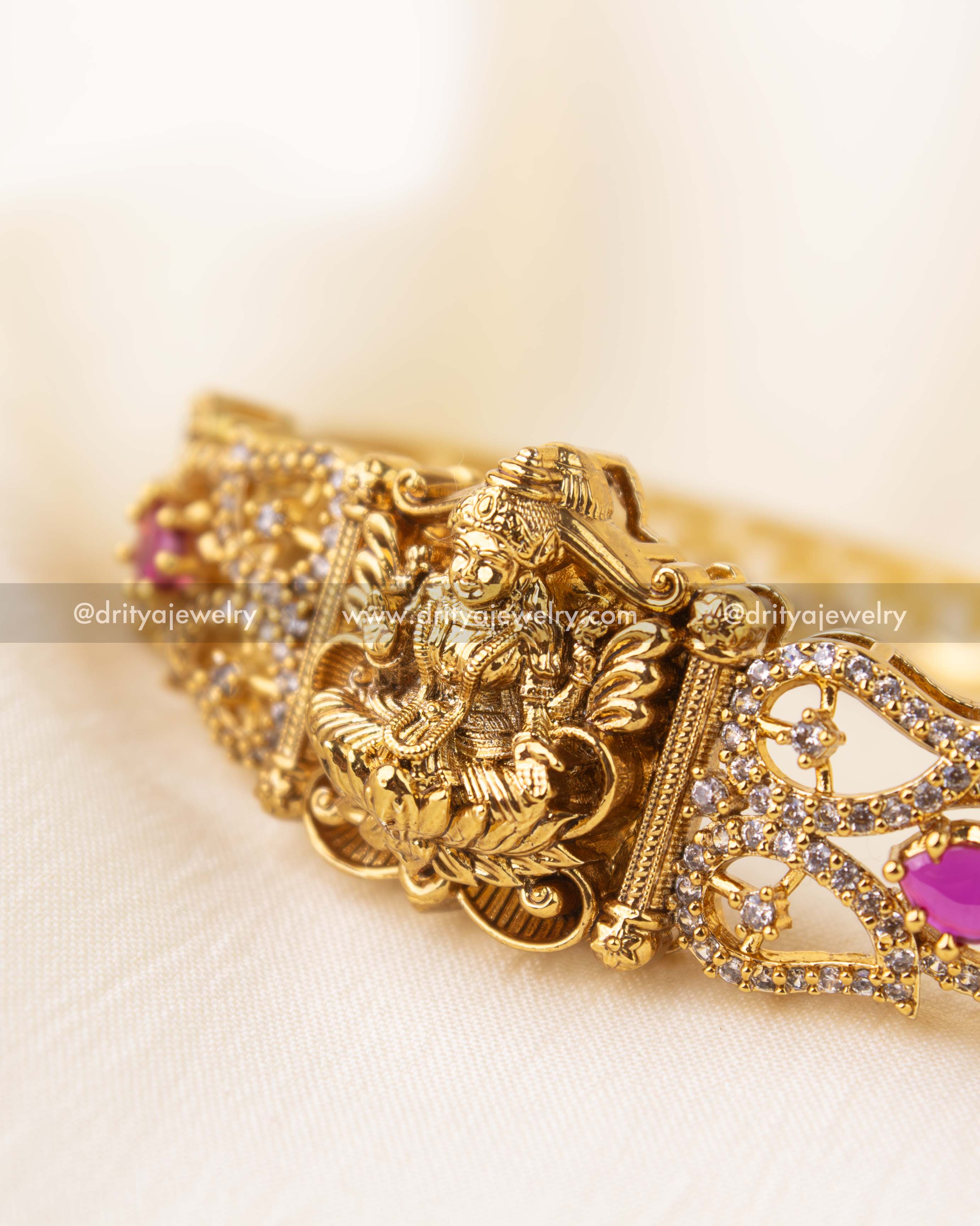Intricately carved Nakshi Kada with pink stones and CZ embellishments