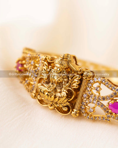 Intricately carved Nakshi Kada with pink stones and CZ embellishments