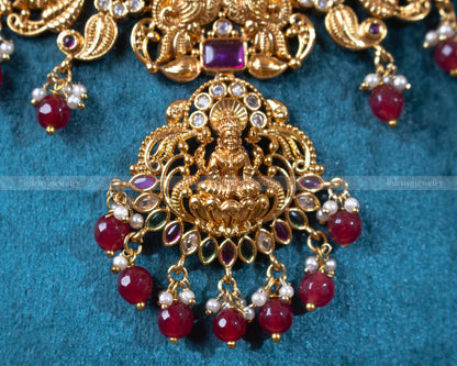 Close-up of Dritya Jewelry's Lakshmi pendant with red beads, highlighting the detailed temple designs and vibrant bead embellishments.