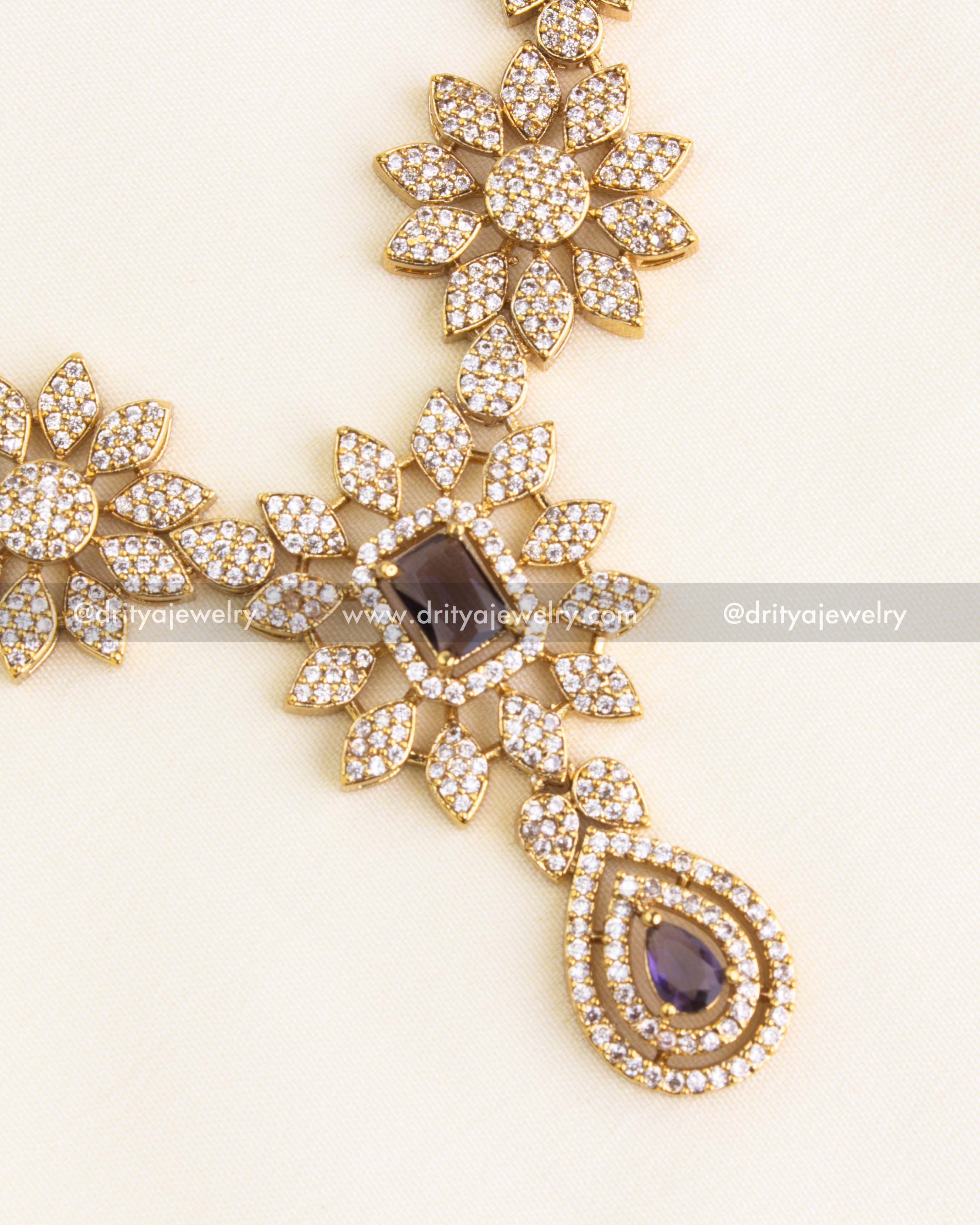 Intricate CZ necklace pendant with purple centerpiece and teardrop design.