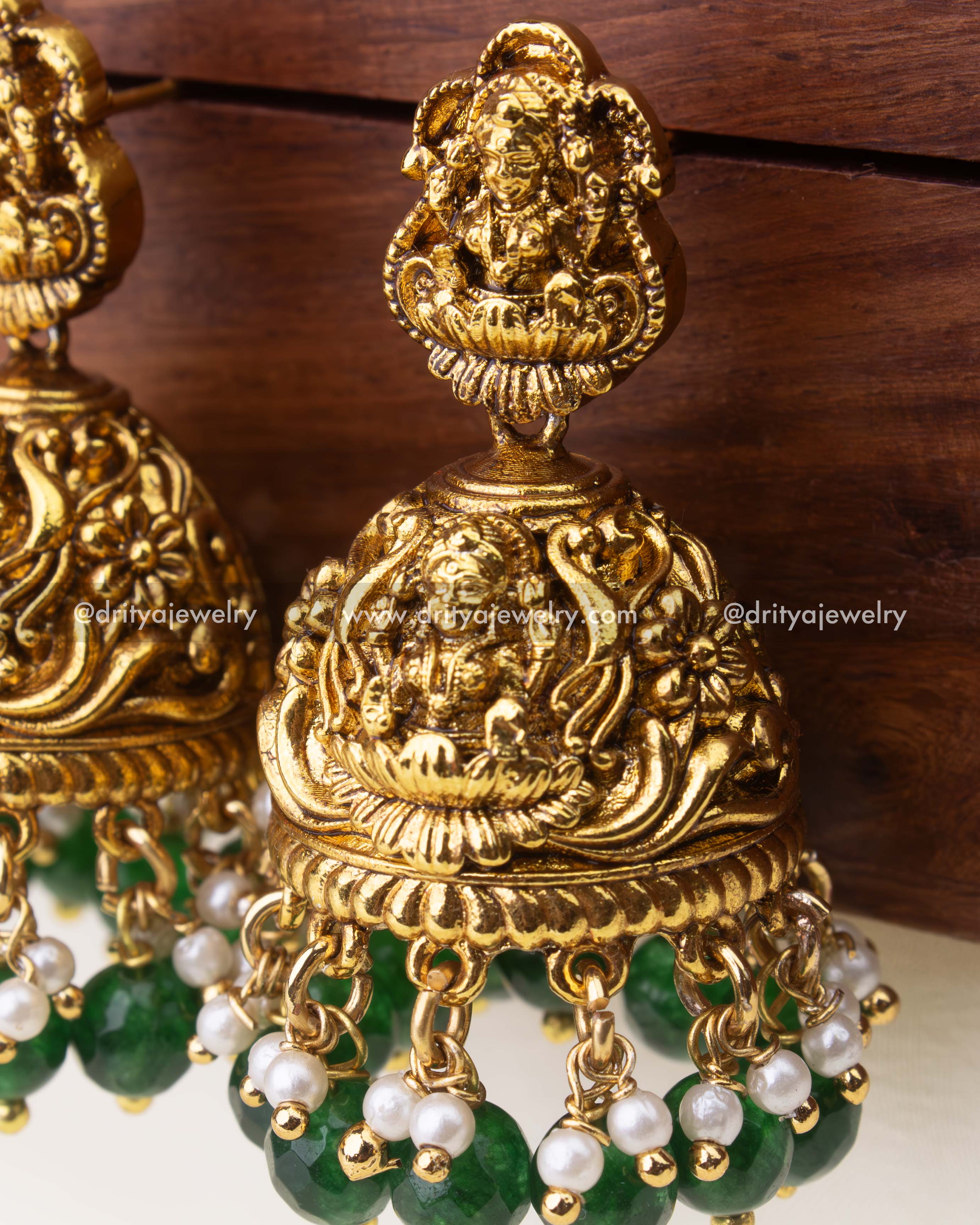 Detailed close-up of nakshi antique Jhumka with green beads and pearl danglers.