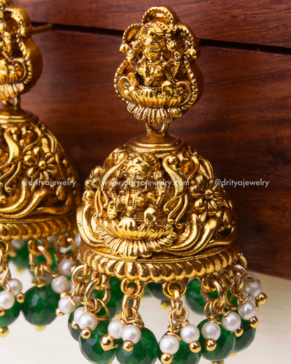 Detailed close-up of nakshi antique Jhumka with green beads and pearl danglers.